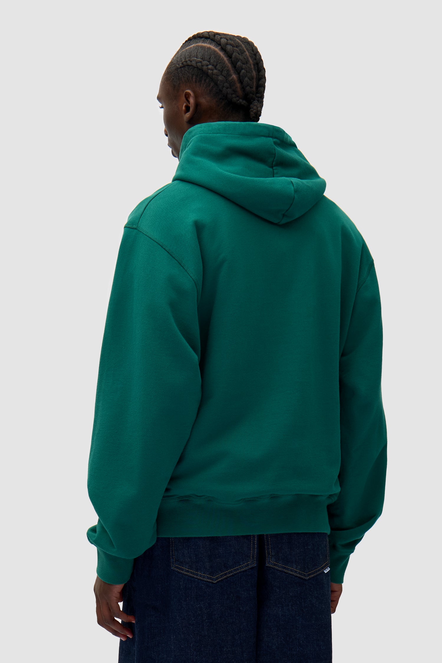 Heart Logo Hoodie in Green worn by a model, half-body back view