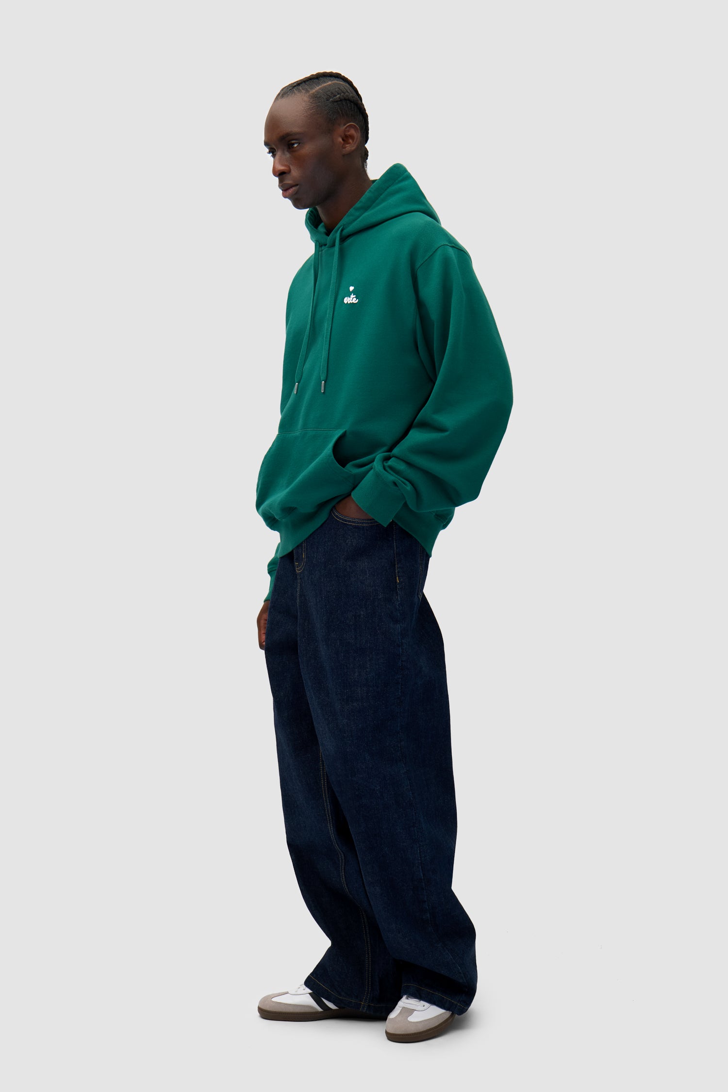 Heart Logo Hoodie in Green worn by a model, full-body side view