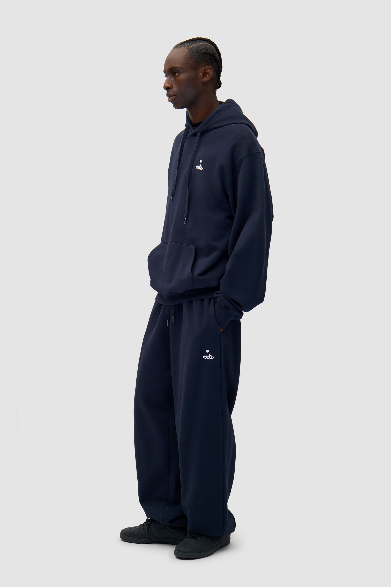 Heart Logo Hoodie in Navy worn by a model, full-body side view