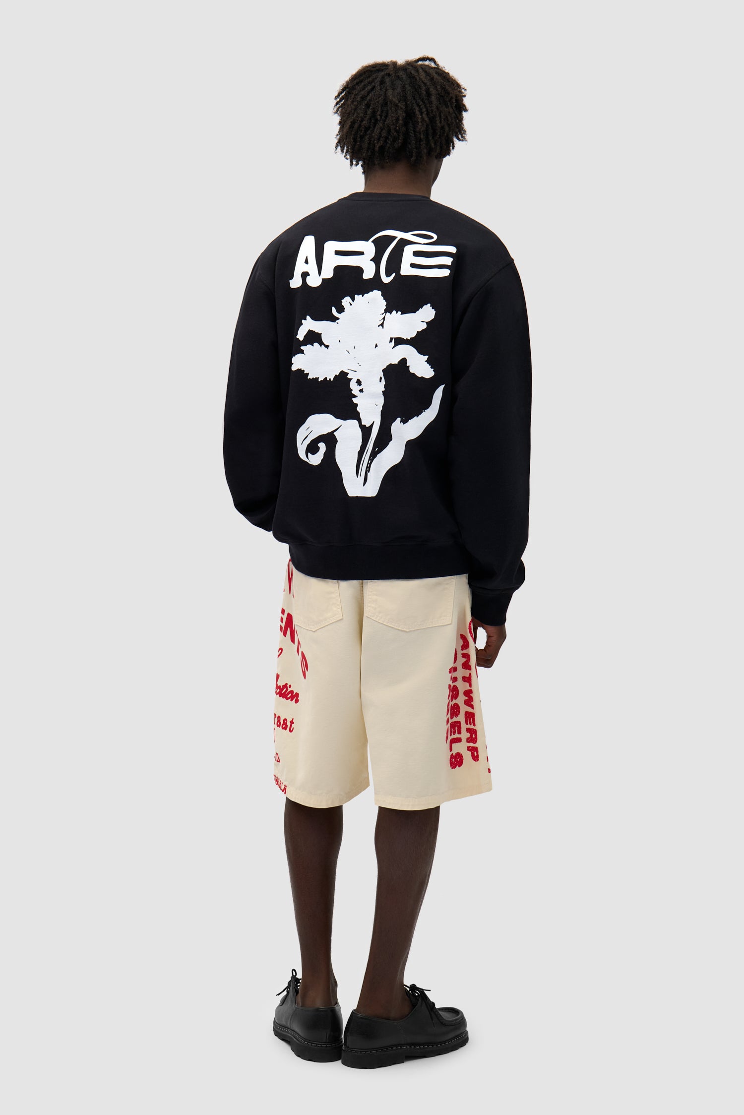 Flower Crewneck in Black worn by a model, full-body back view