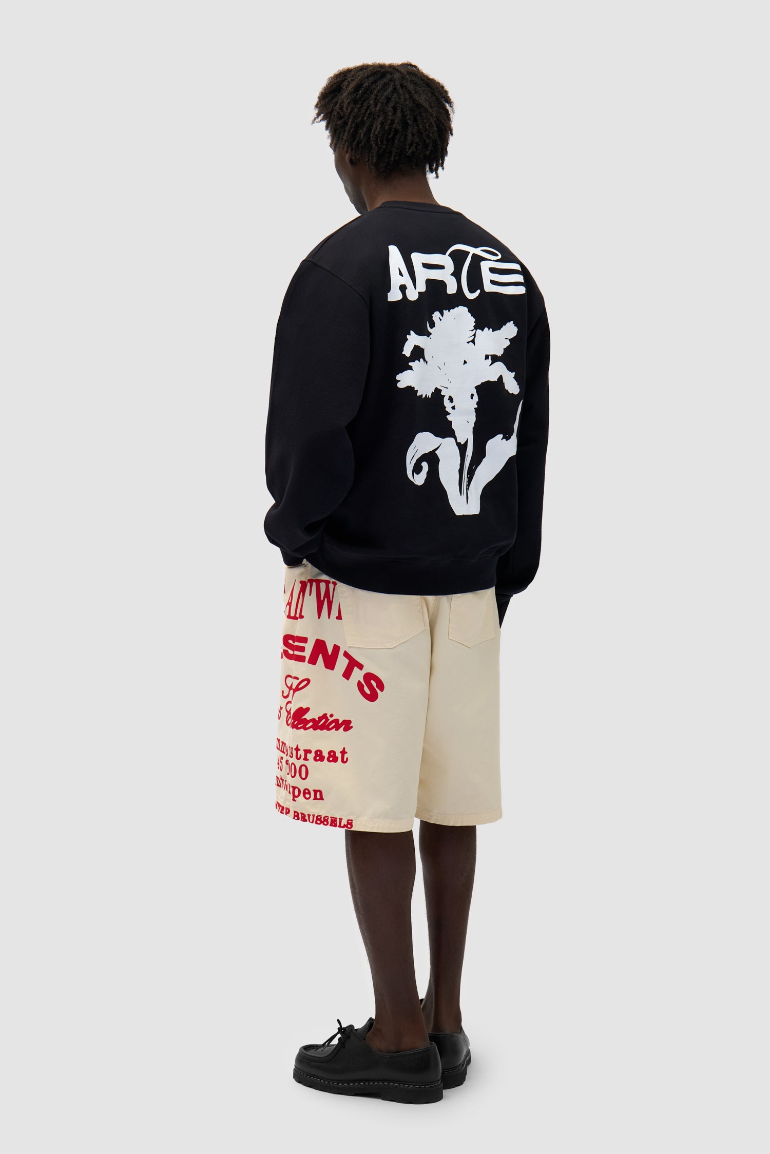 Flower Crewneck in Black worn by a model, full-body side view