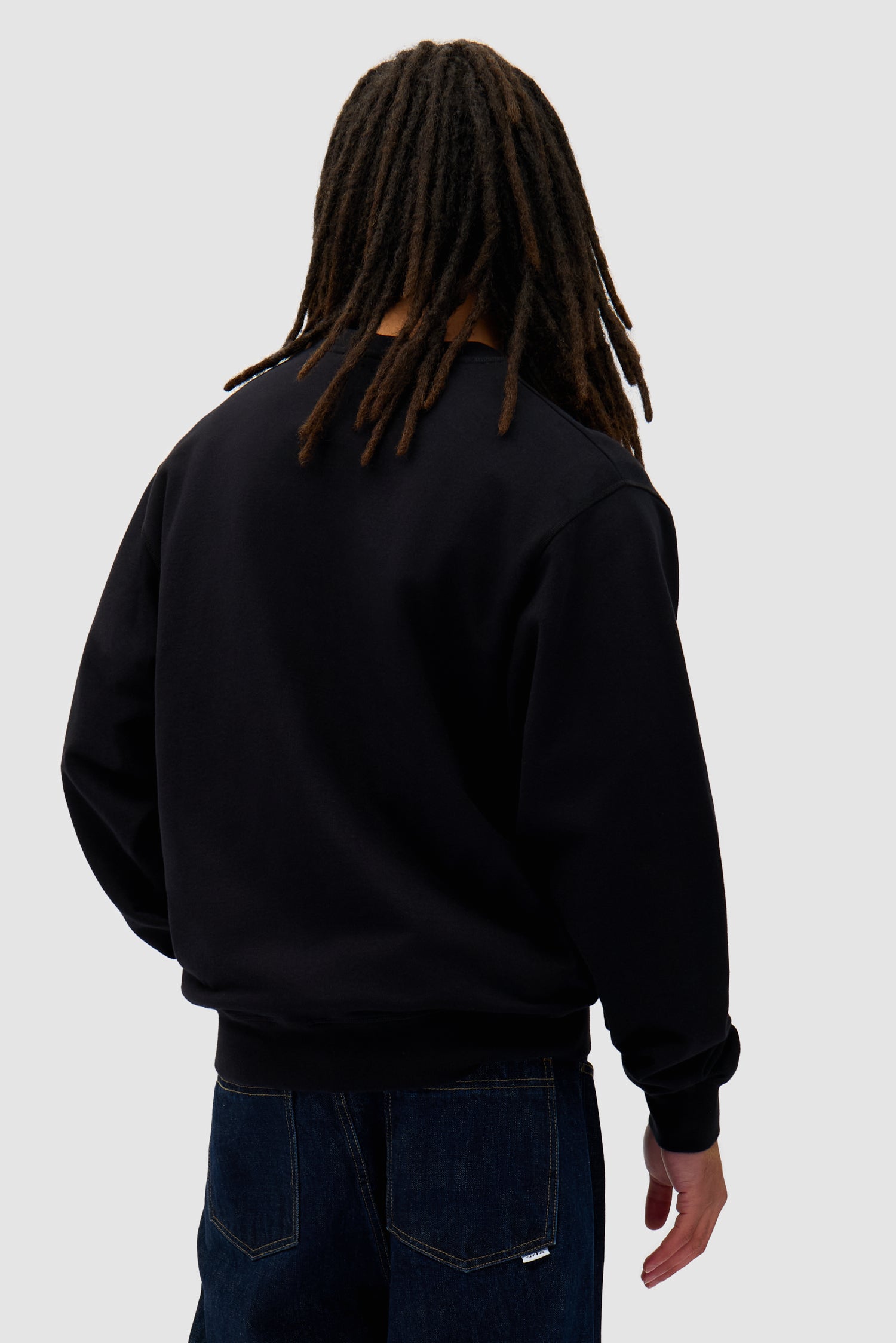 Heart Crewneck in Black worn by a model, half-body back view