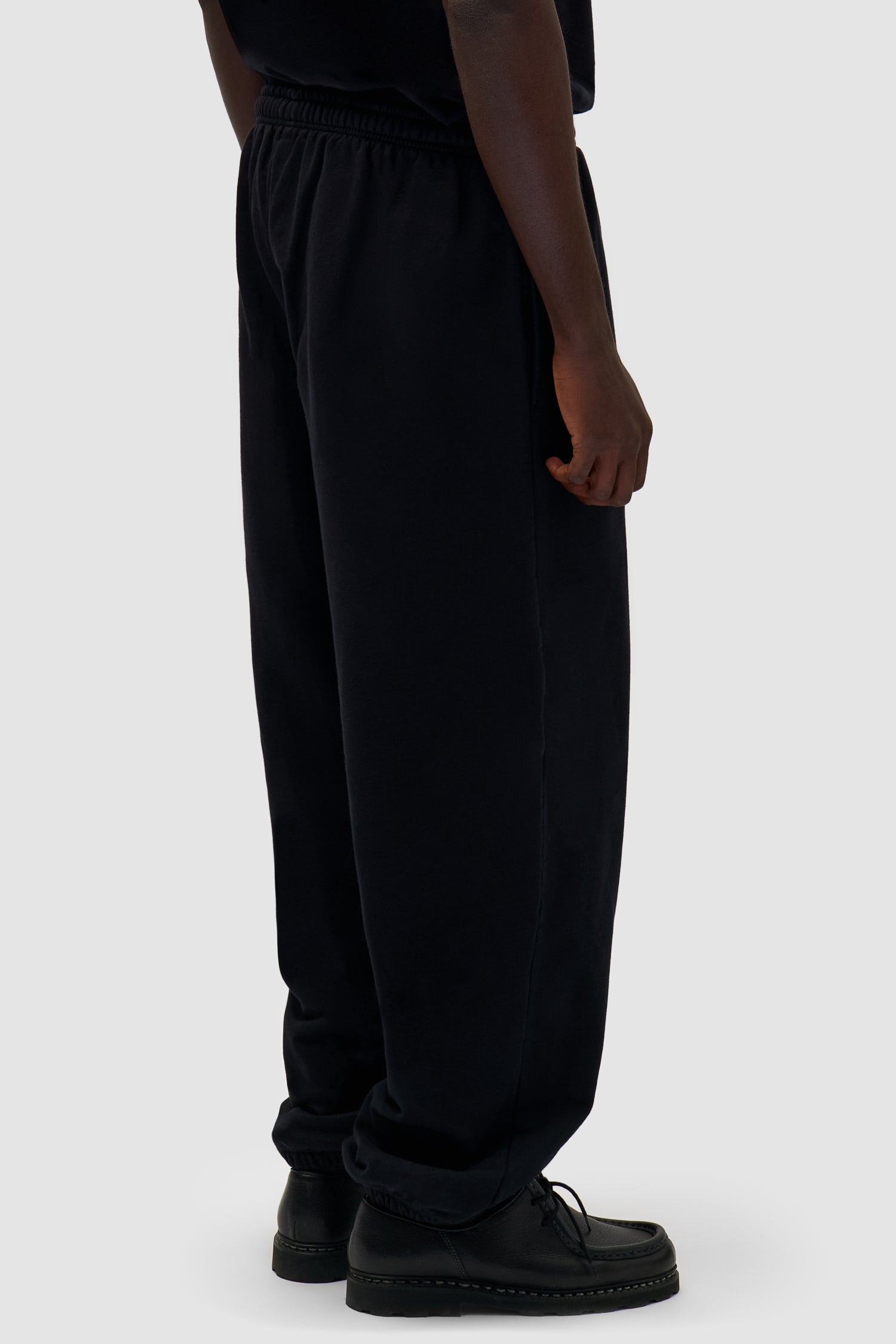 Heart Logo Sweatpants in Black worn by a model, half-body back view
