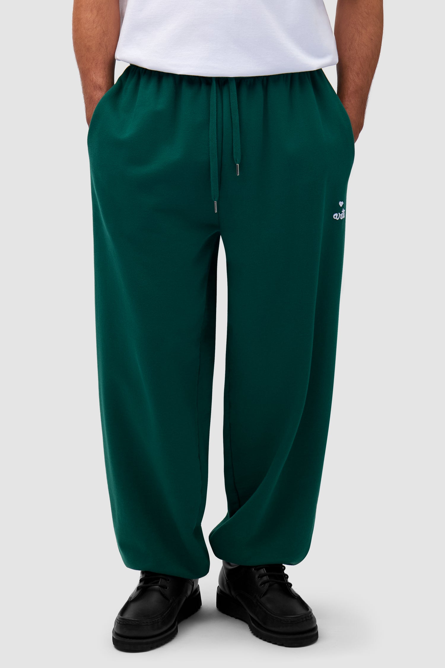 Heart Logo Sweatpants in Green worn by a model, half-body side view