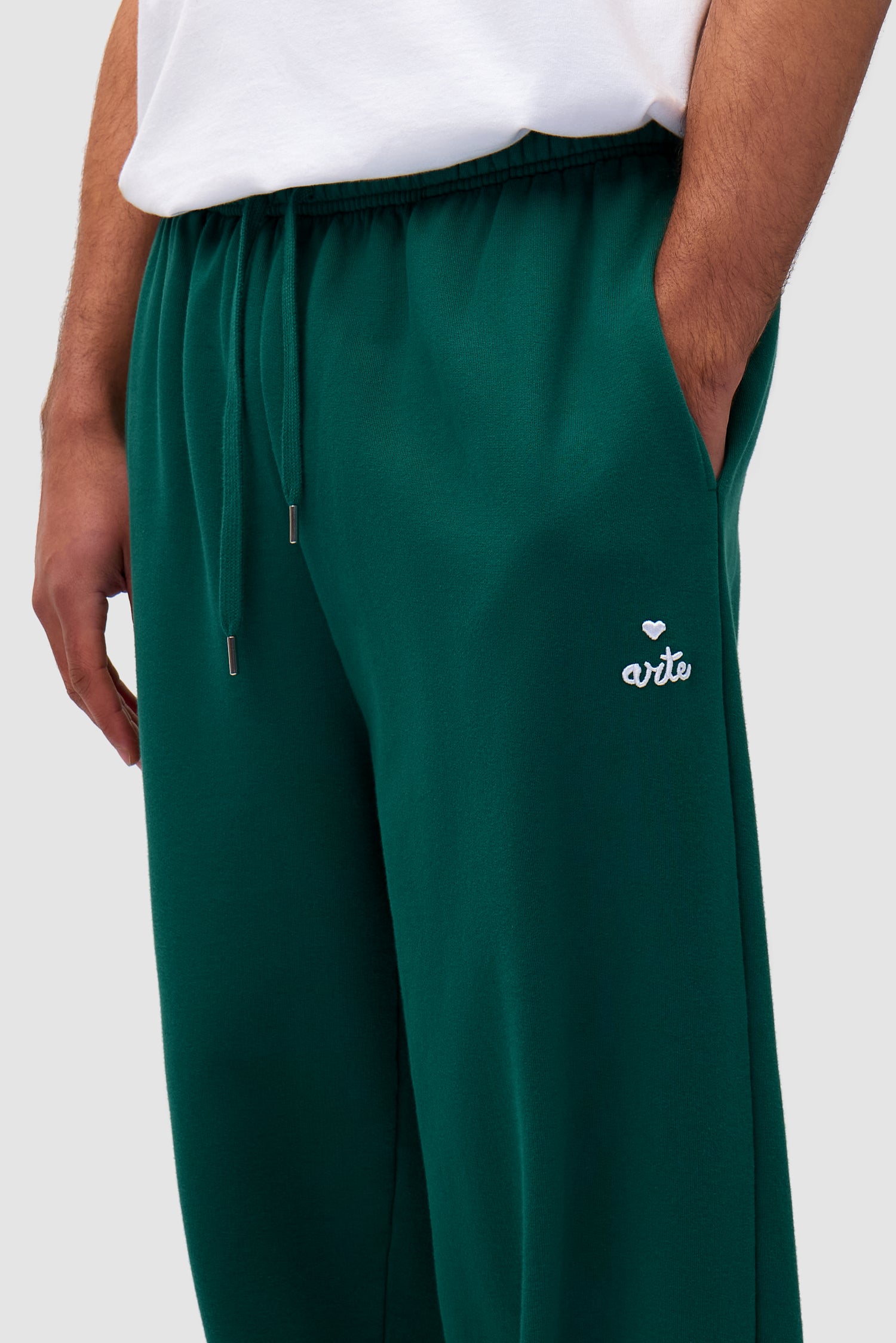 Detail view of Heart Logo Sweatpants in Green worn by a model, showing the pocket logo