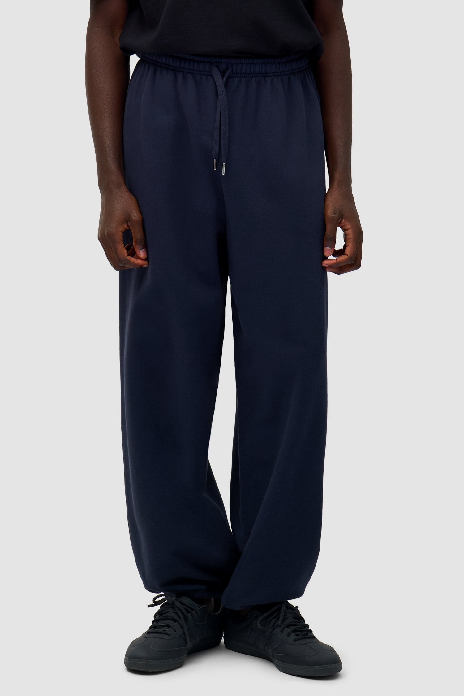 Heart Logo Sweatpants in Navy worn by a model, half-body side view
