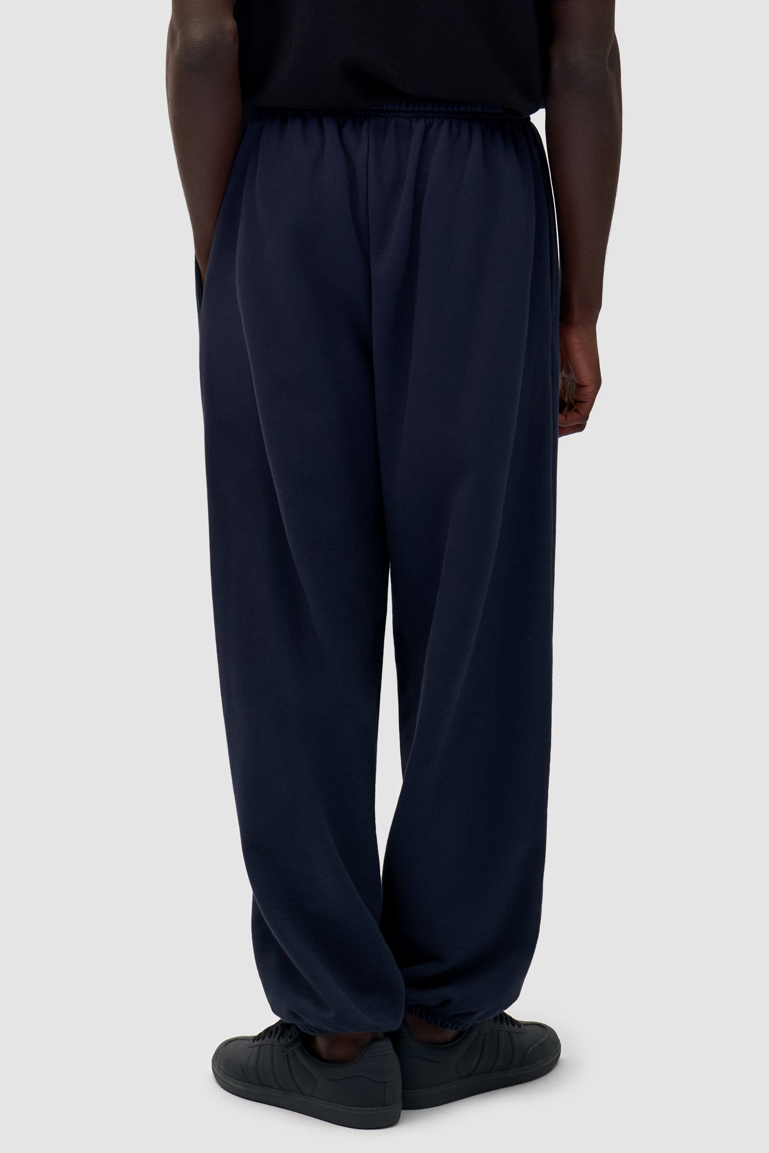 Heart Logo Sweatpants in Navy worn by a model, half-body back view