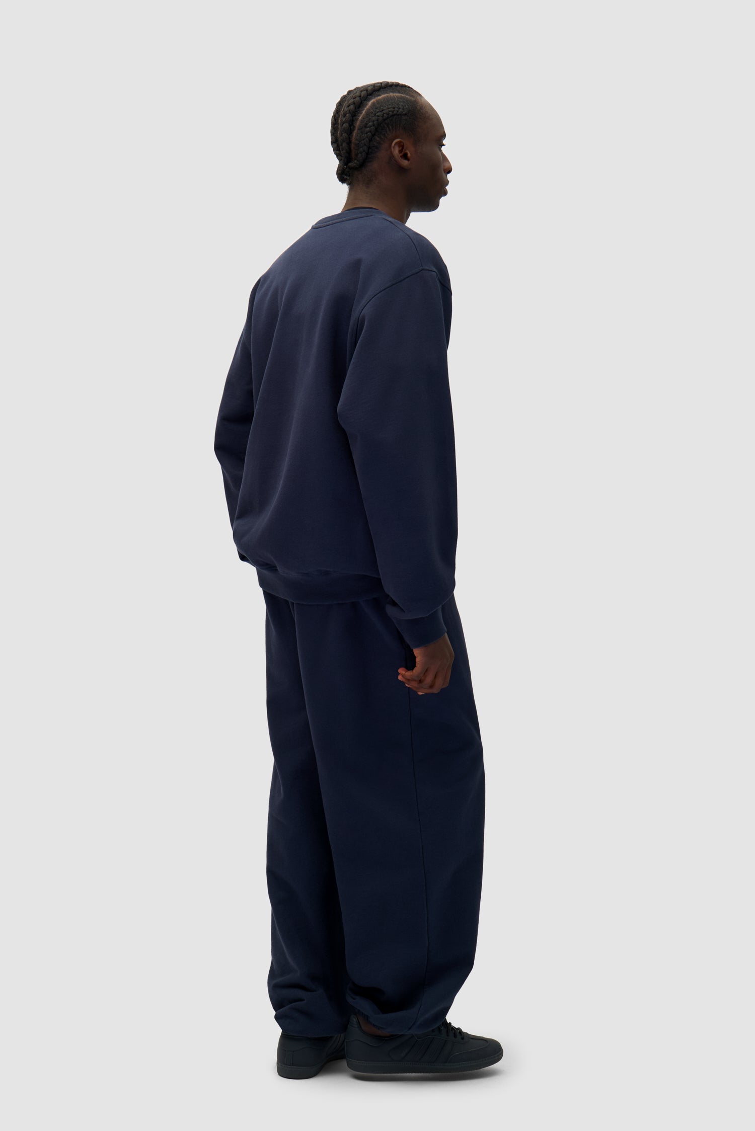 Heart Logo Sweatpants in Navy worn by a model, full-body back view