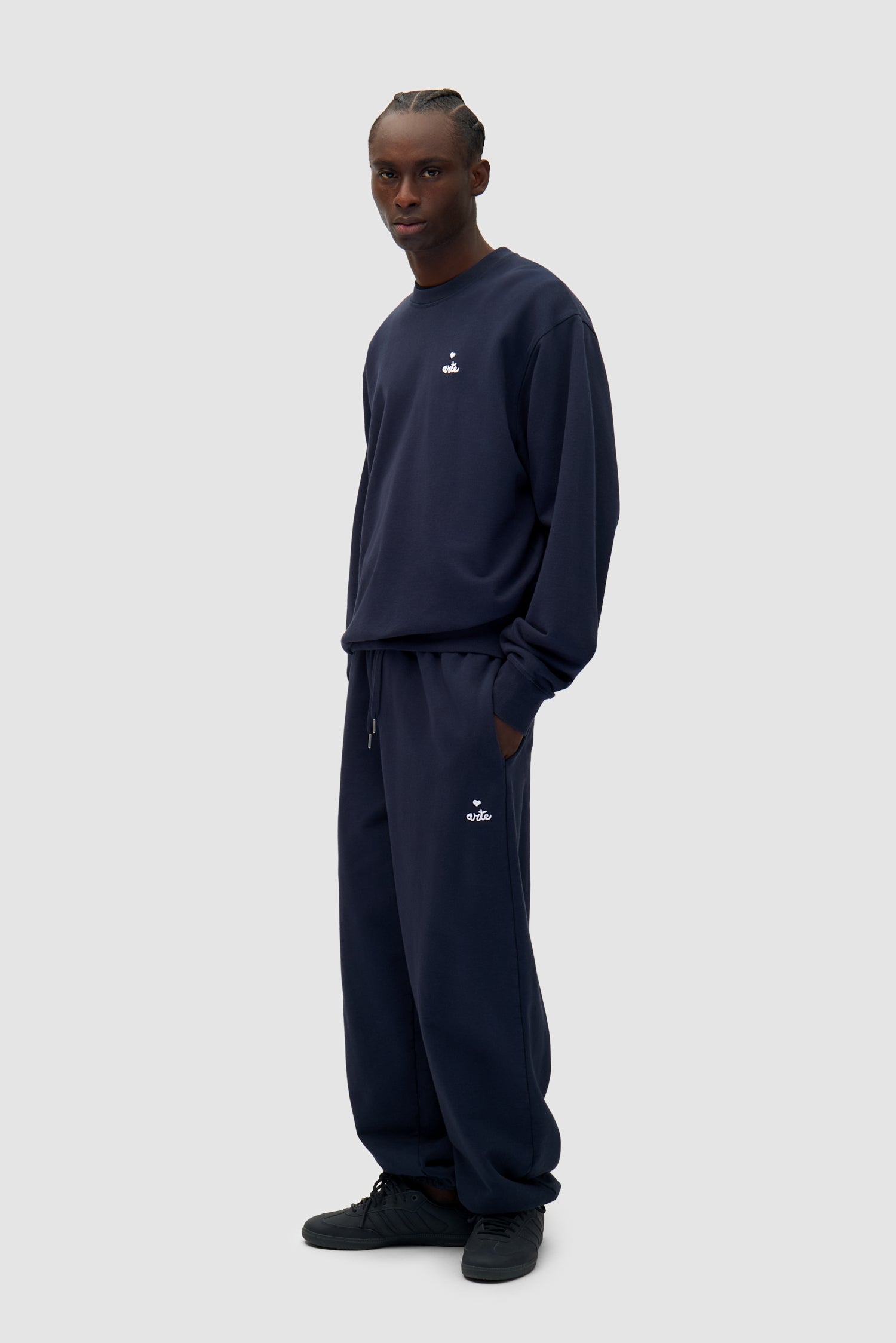 Heart Logo Sweatpants in Navy worn by a model, full-body side view