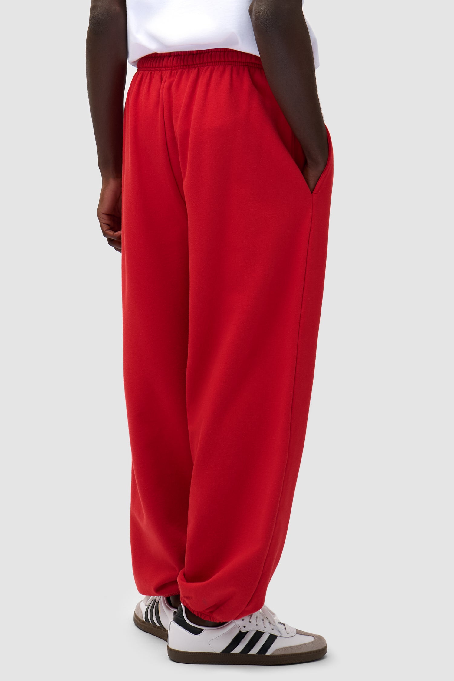 Heart Logo Sweatpants in Red worn by a model, half-body back view