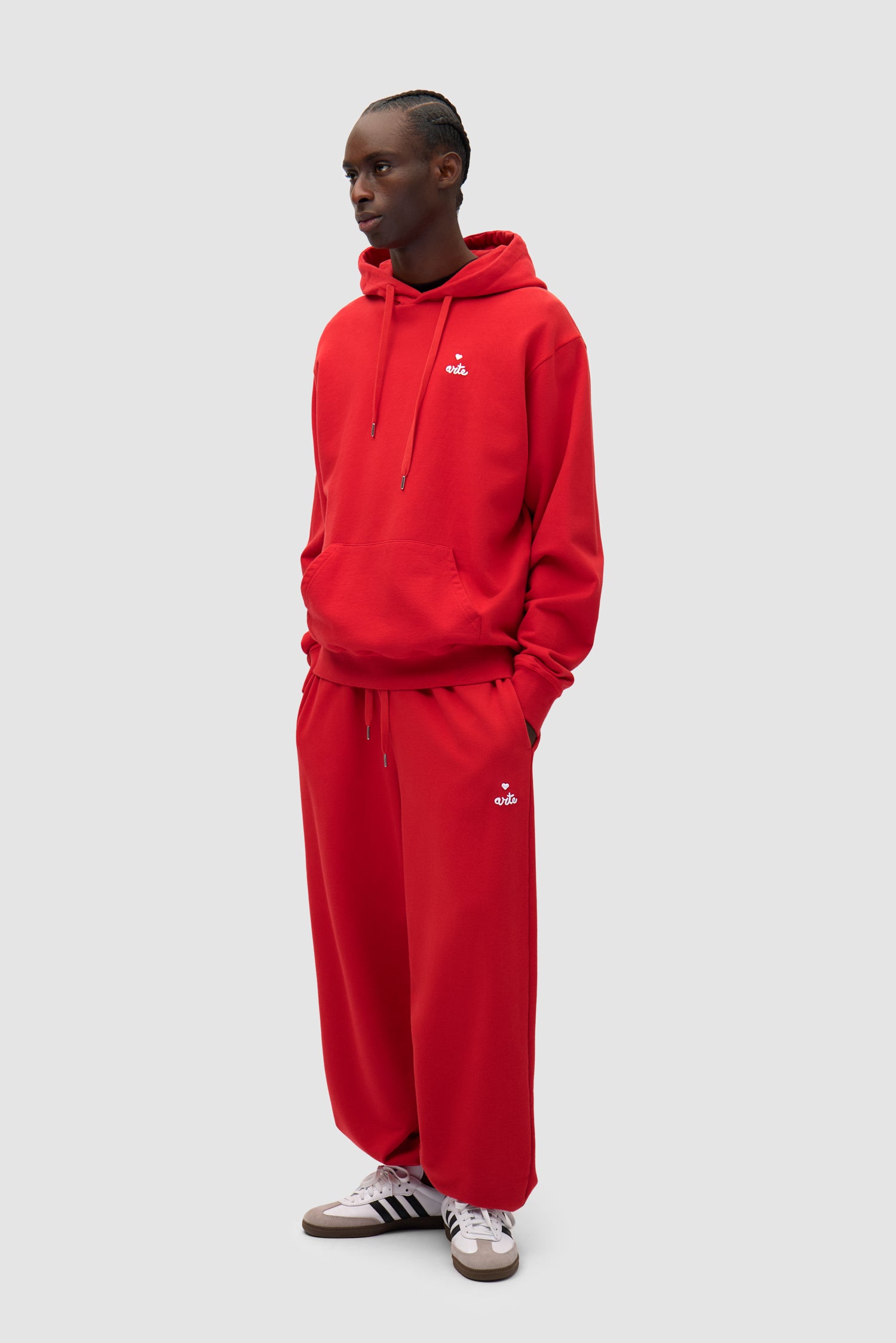 Heart Logo Sweatpants in Red worn by a model, full-body side view
