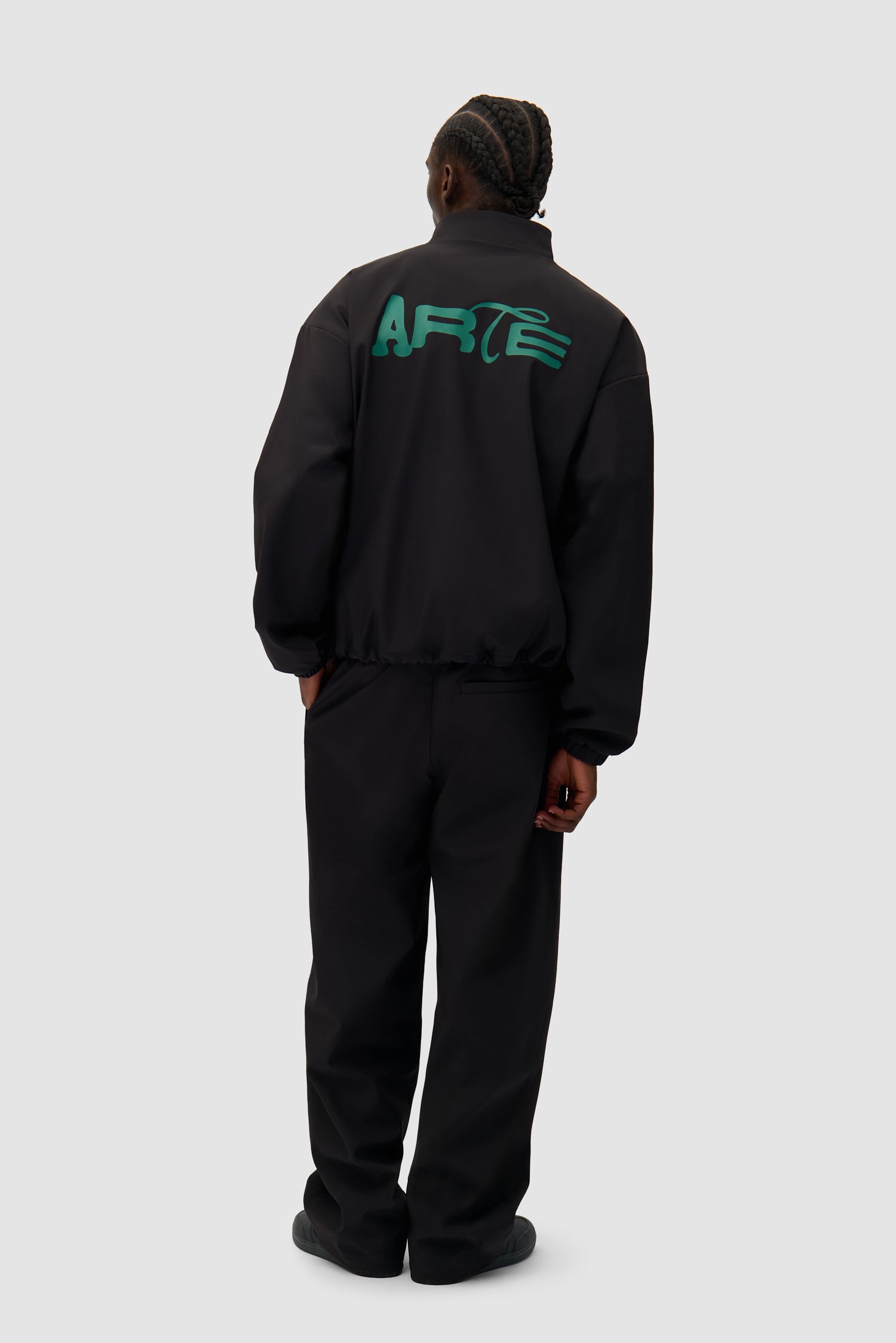 Green Logo Jacket in Black worn by a model, full-body back view