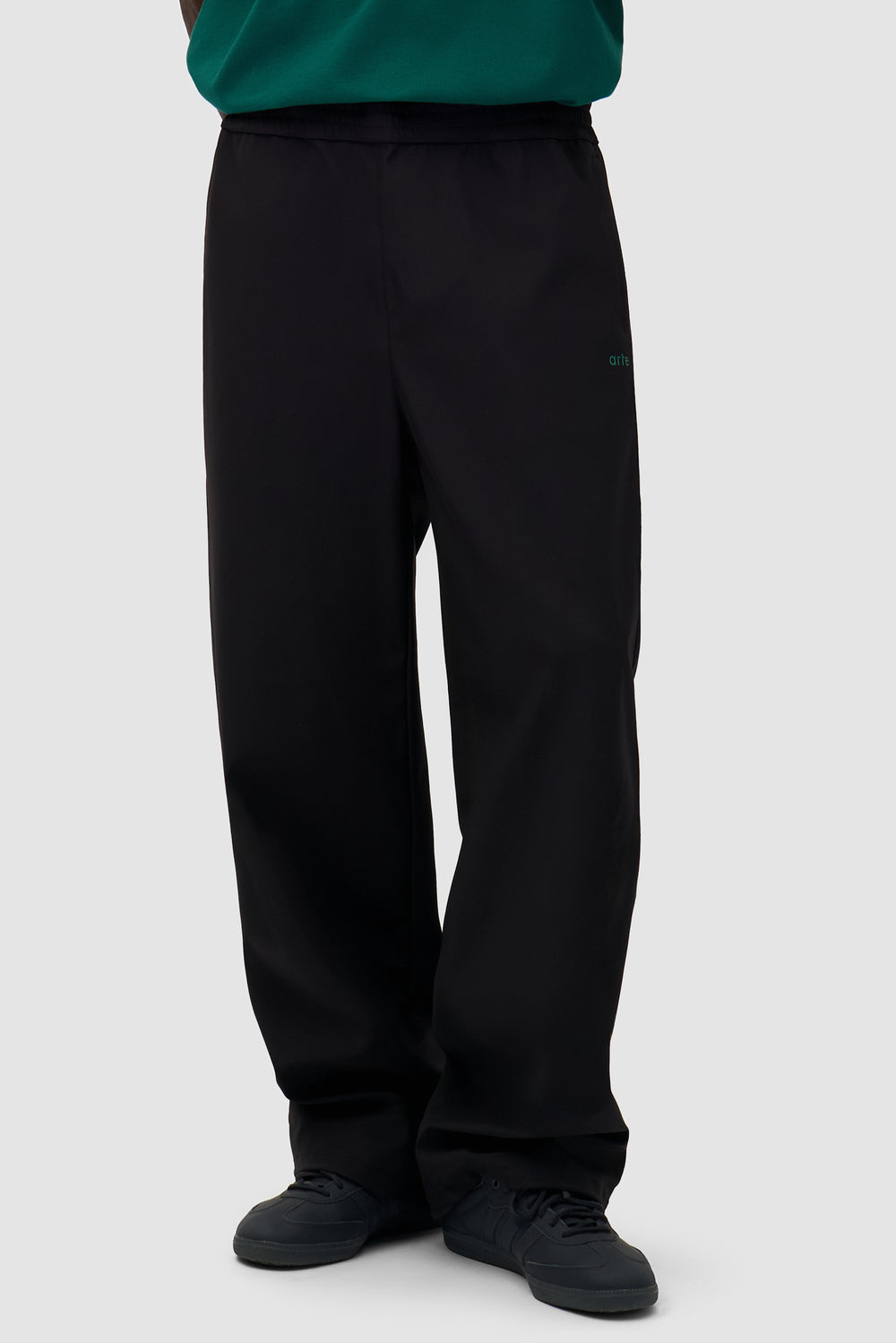 Green Logo Polyester Pants in Black worn by a model, half-body front view