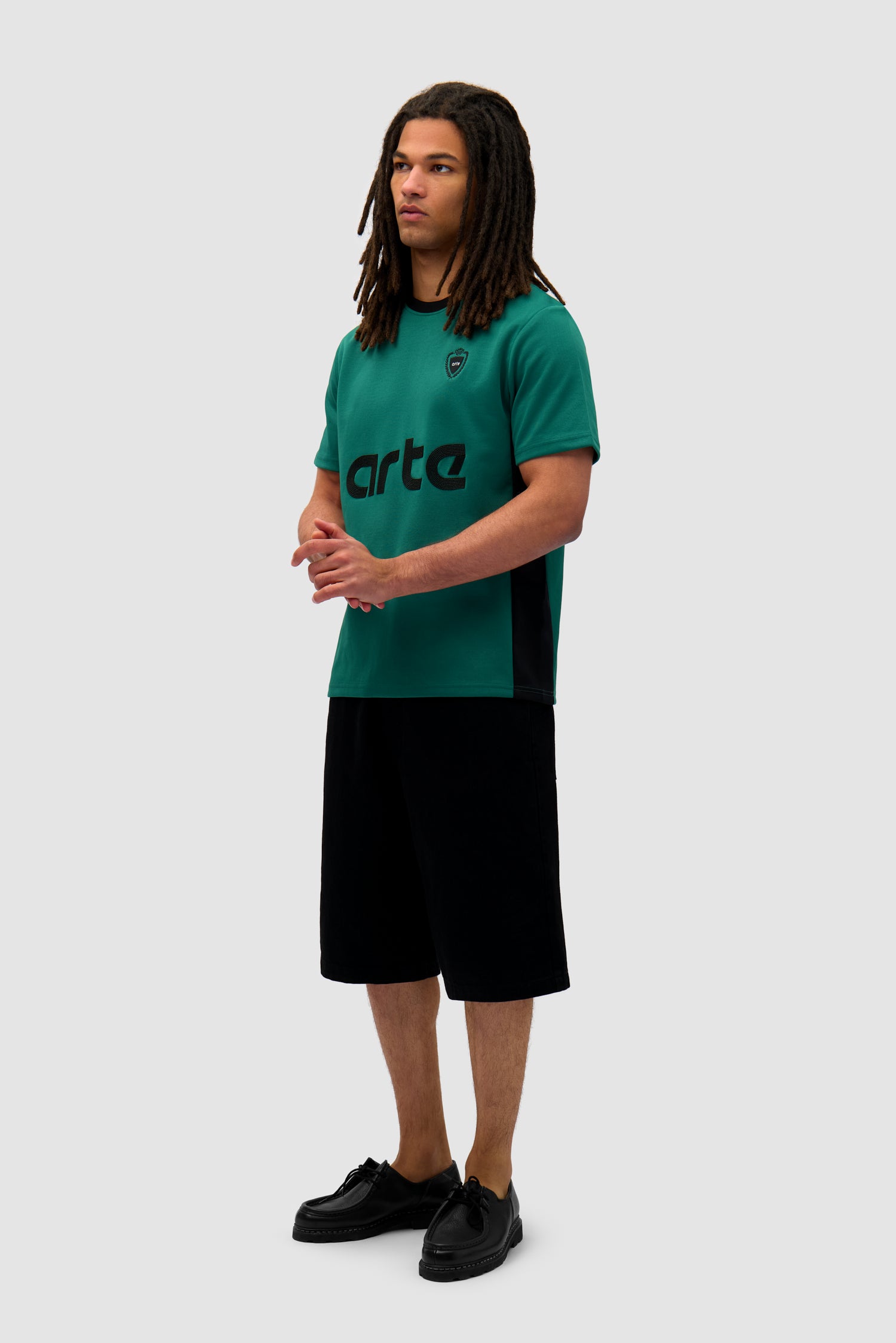 Footbal T-shirt in Green/Black worn by a model, full-body side view