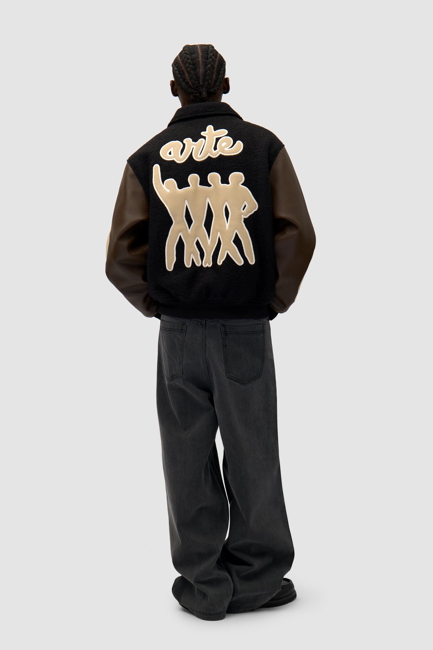 Varsity Jacket in Black/Brown worn by a model, full-body back view