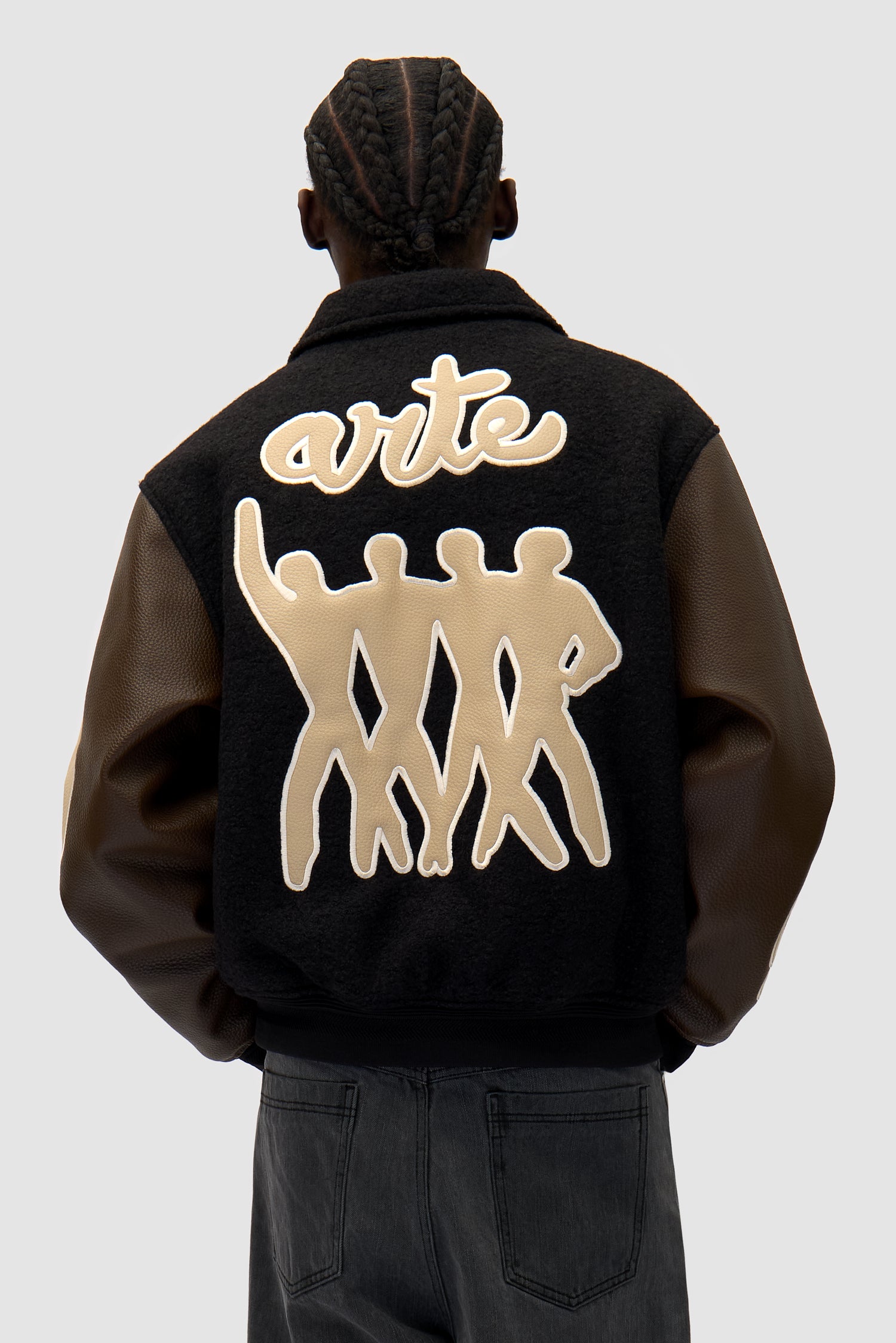 Varsity Jacket in Black/Brown worn by a model, half-body back view