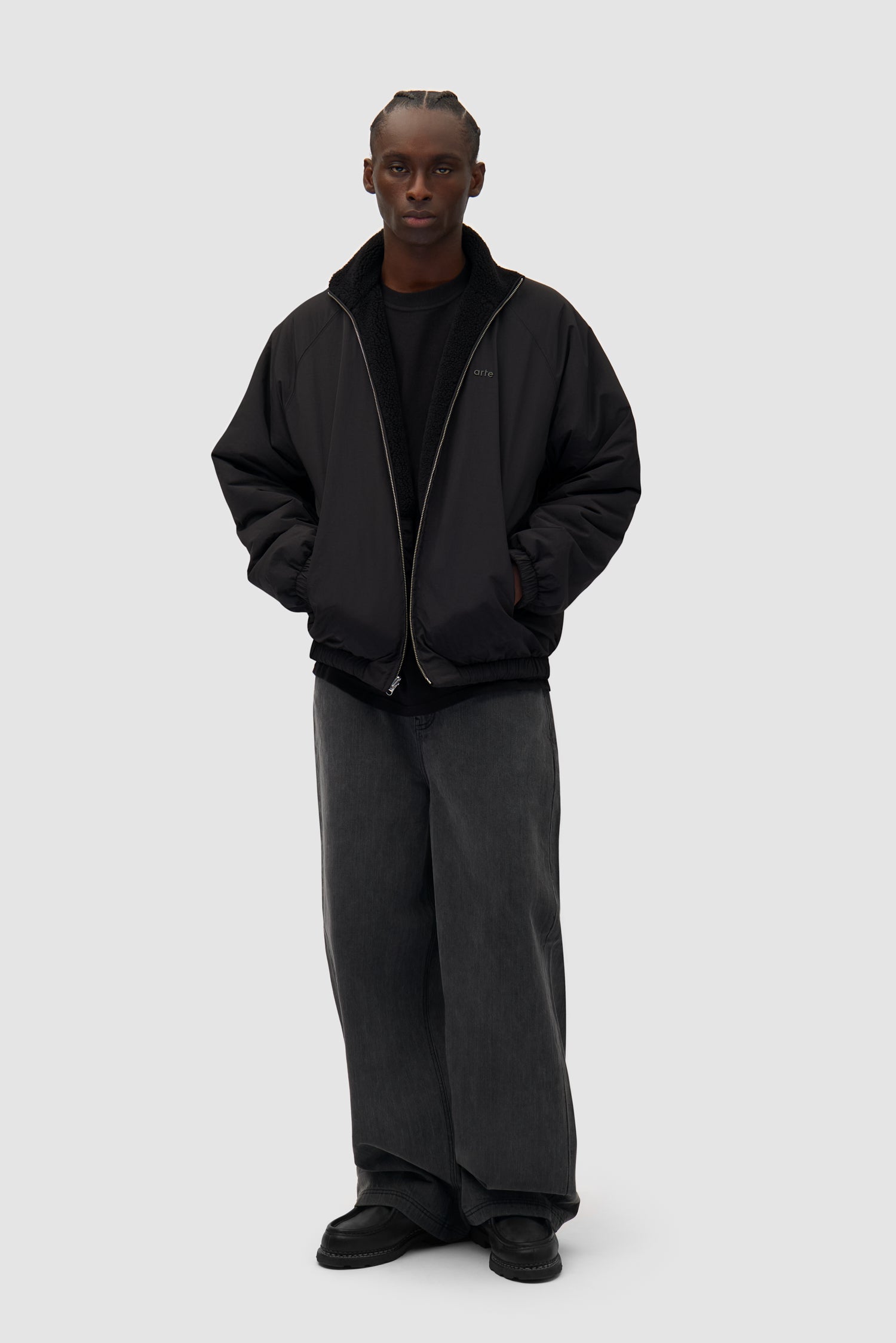 Reversible Polar Jacket in Black worn reversed by a model, full-body front view