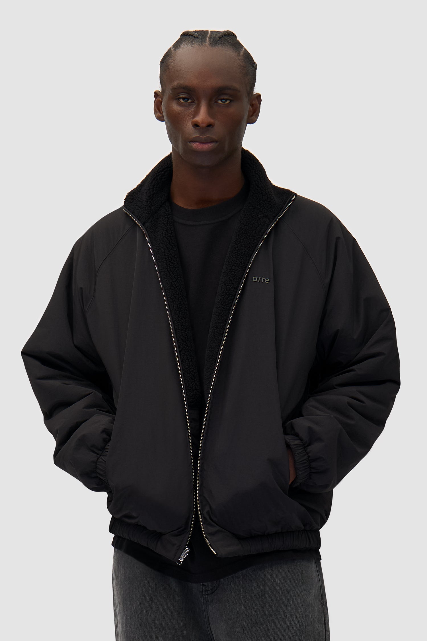 Reversible Polar Jacket in Black worn reversed by a model, half-body front view