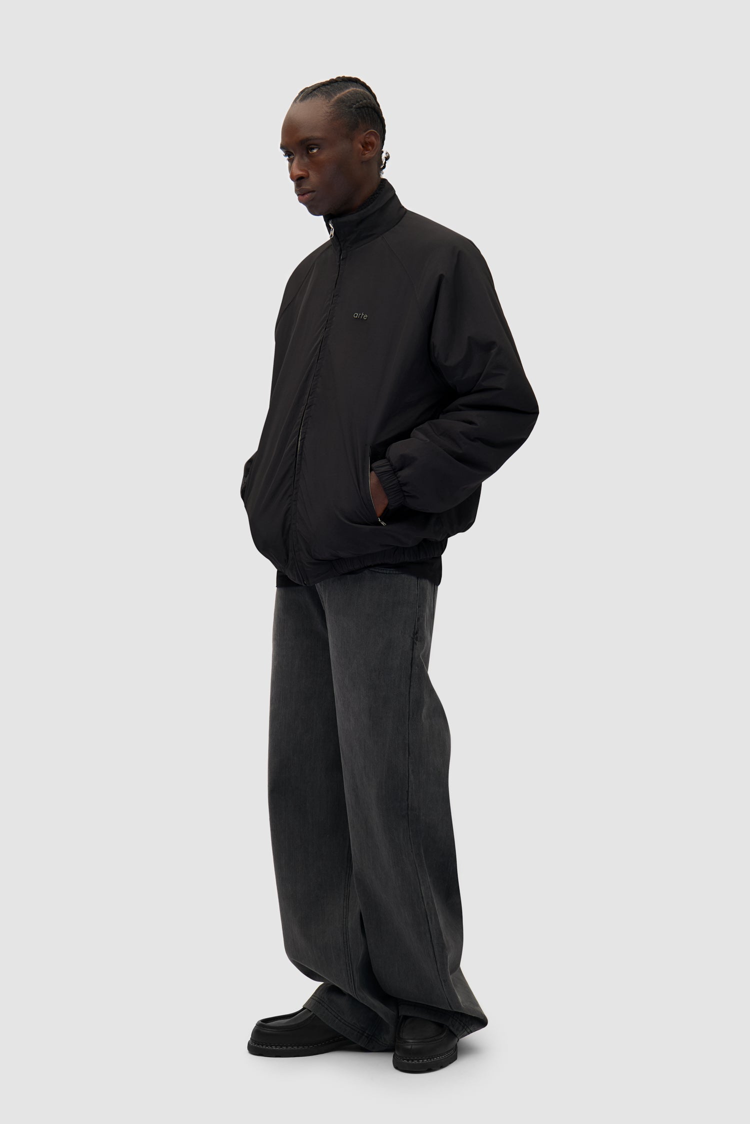 Reversible Polar Jacket in Black worn reversed by a model, full-body side view