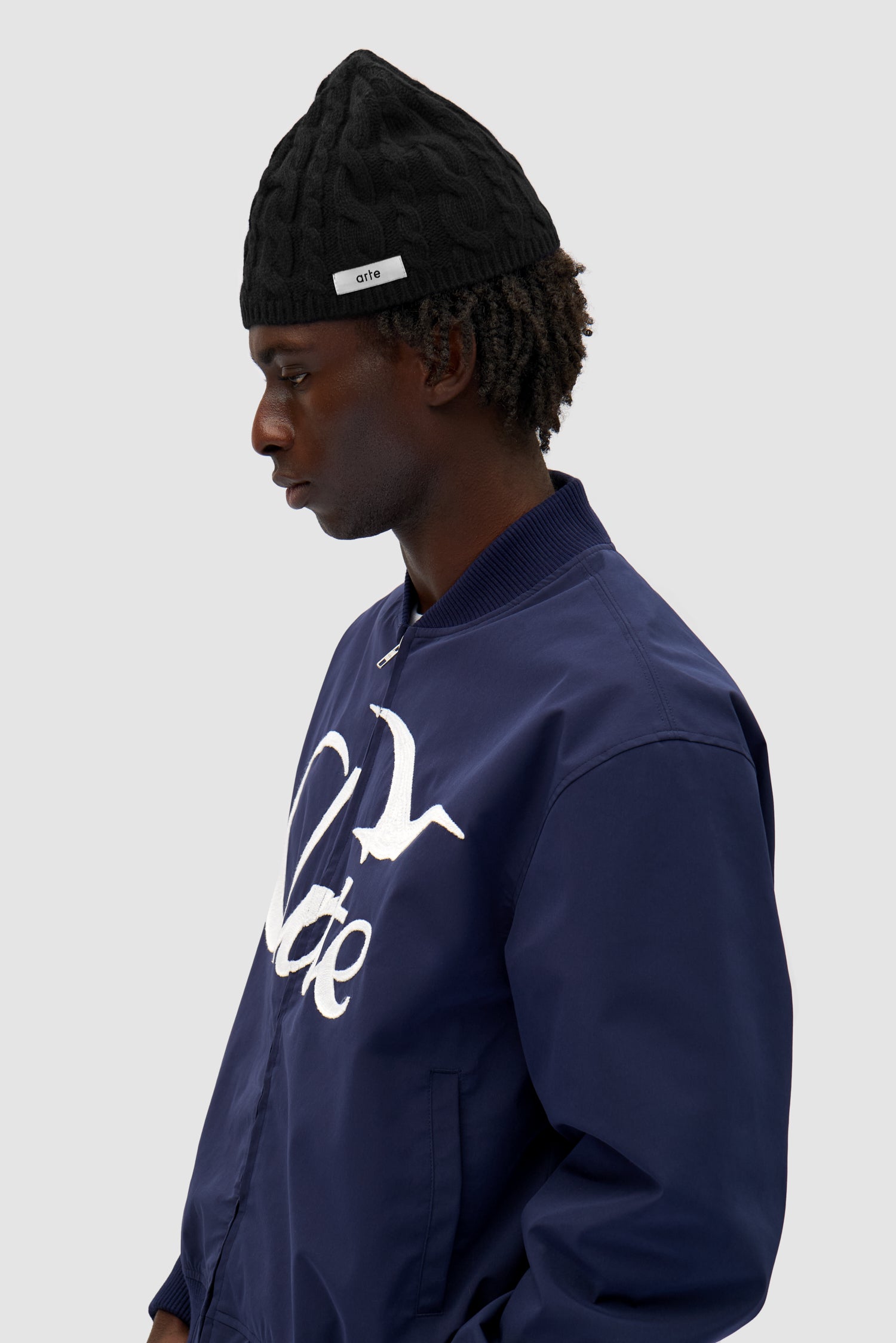 Braided Beanie in Black worn by a model, half-body front view