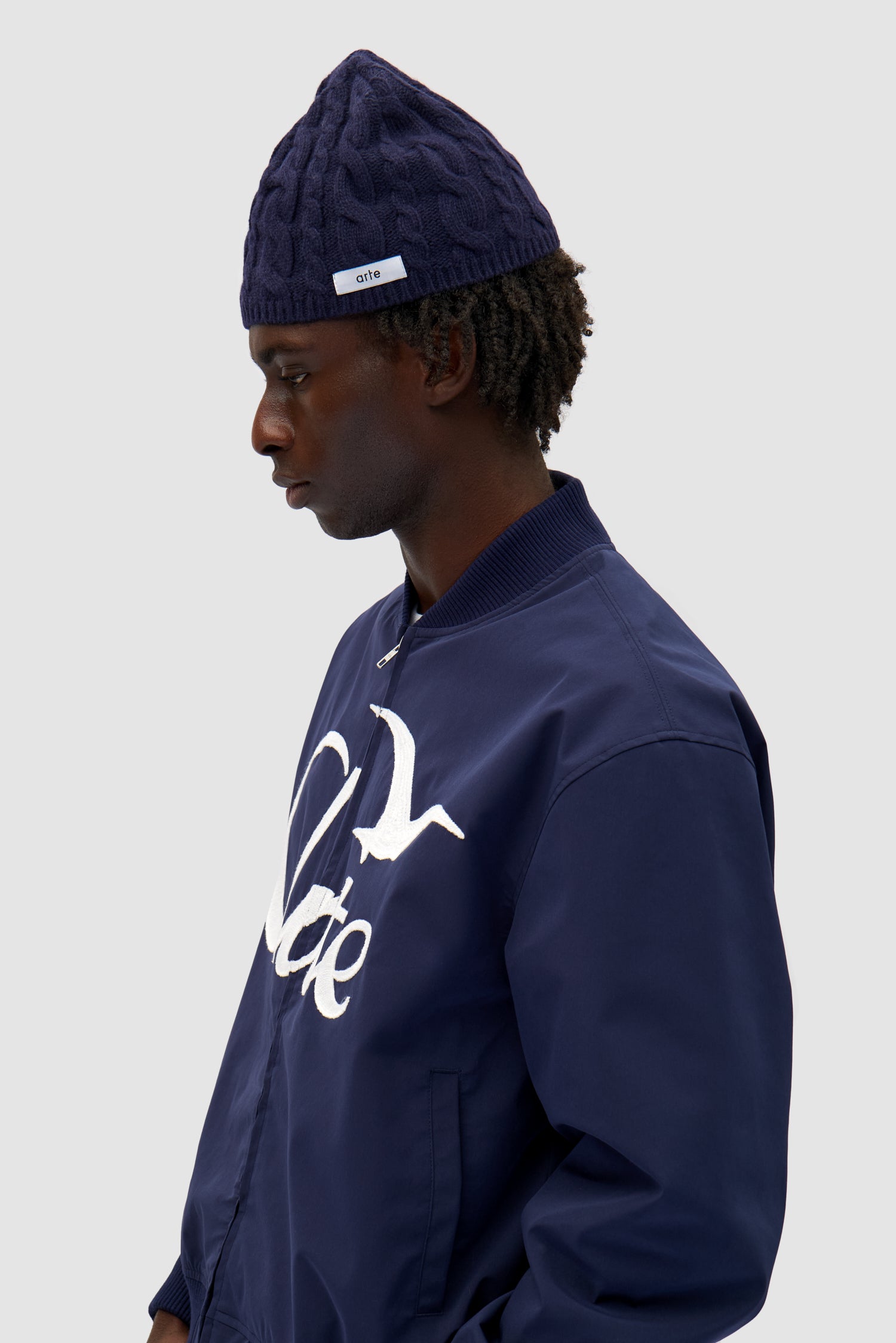 Braided Beanie in Navy worn by a model, half-body front view