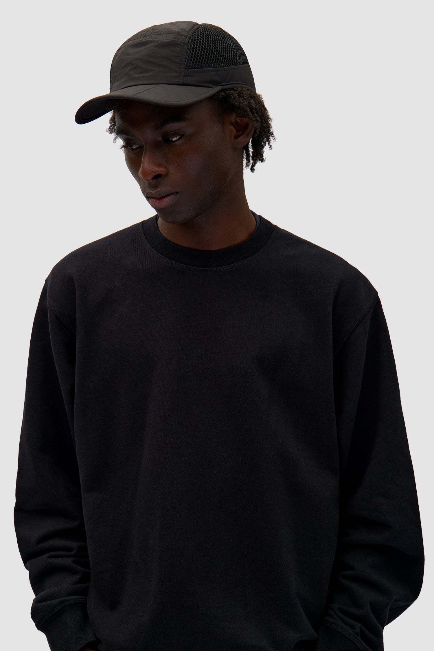 Mesh 5Panel cap in Black worn by a model, full-body front view