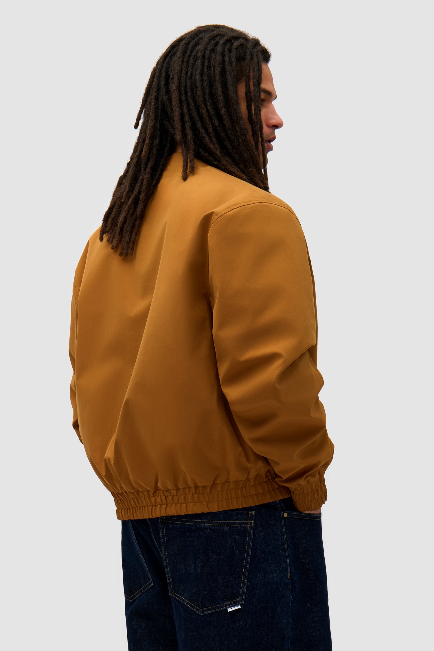 Reversible Nylon Jacket in Brown/Yellow worn by a model, half-body back view