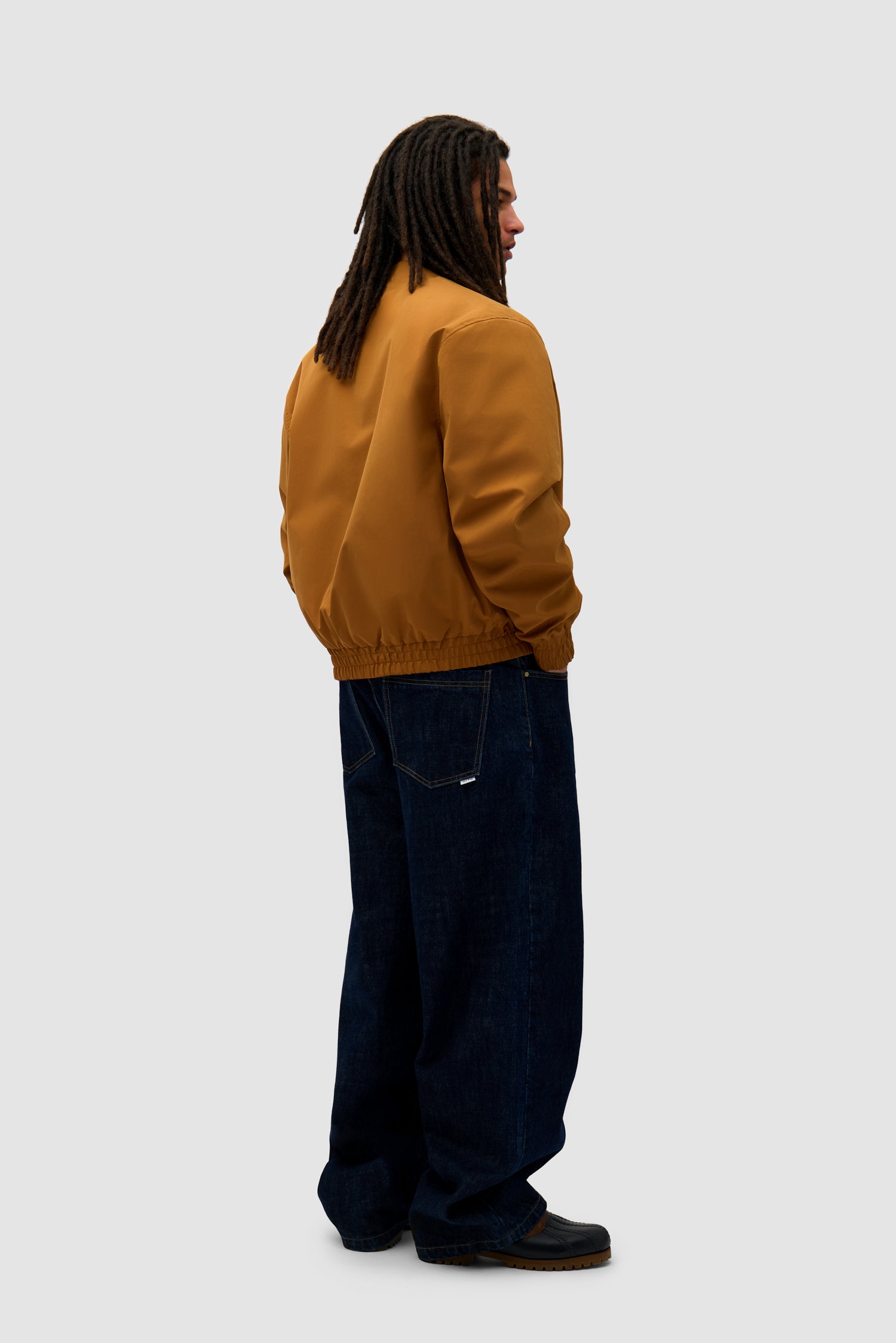 Reversible Nylon Jacket in Brown/Yellow worn by a model, full-body back view