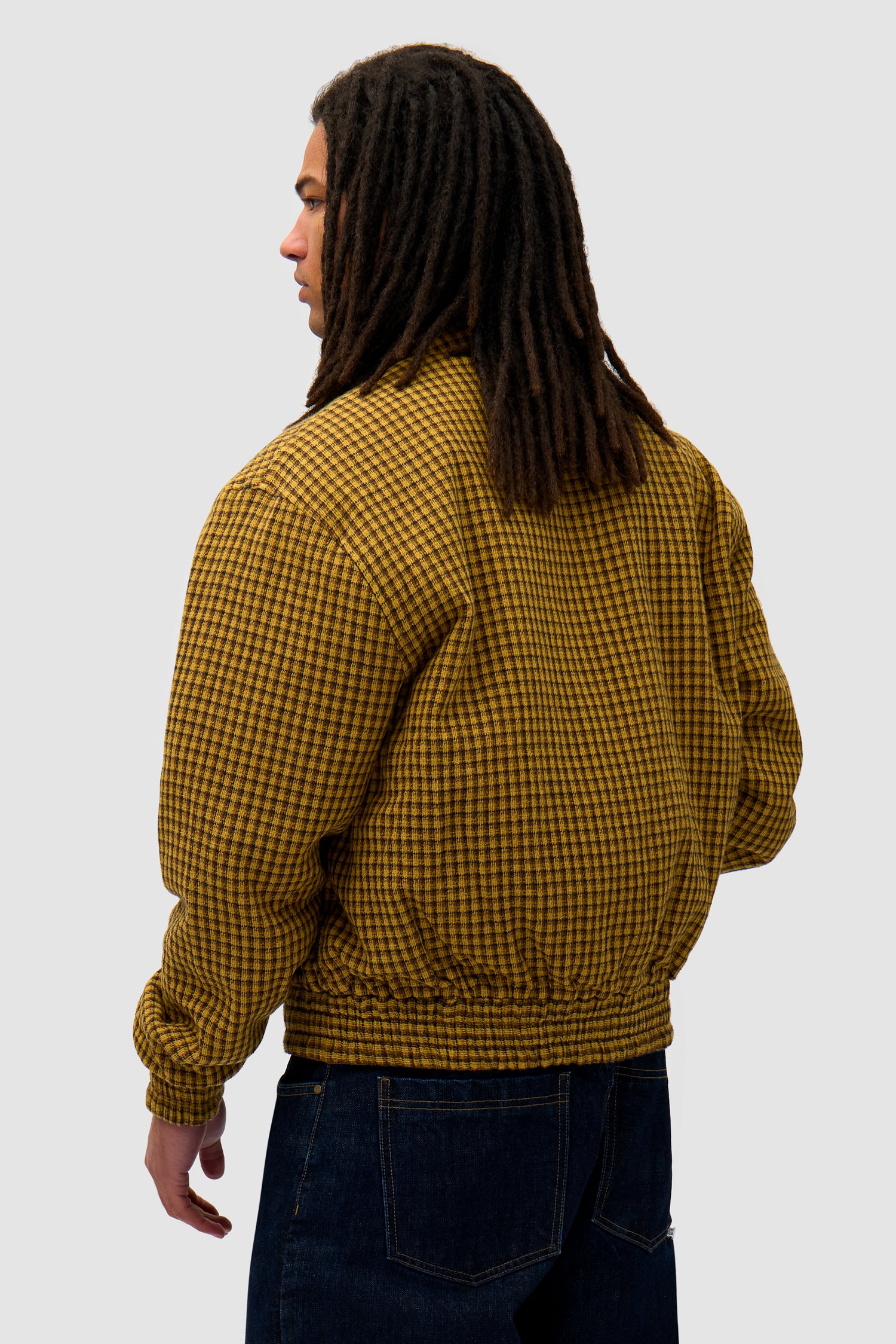 Reversible Nylon Jacket in Brown/Yellow worn reversed by a model, half-body back view