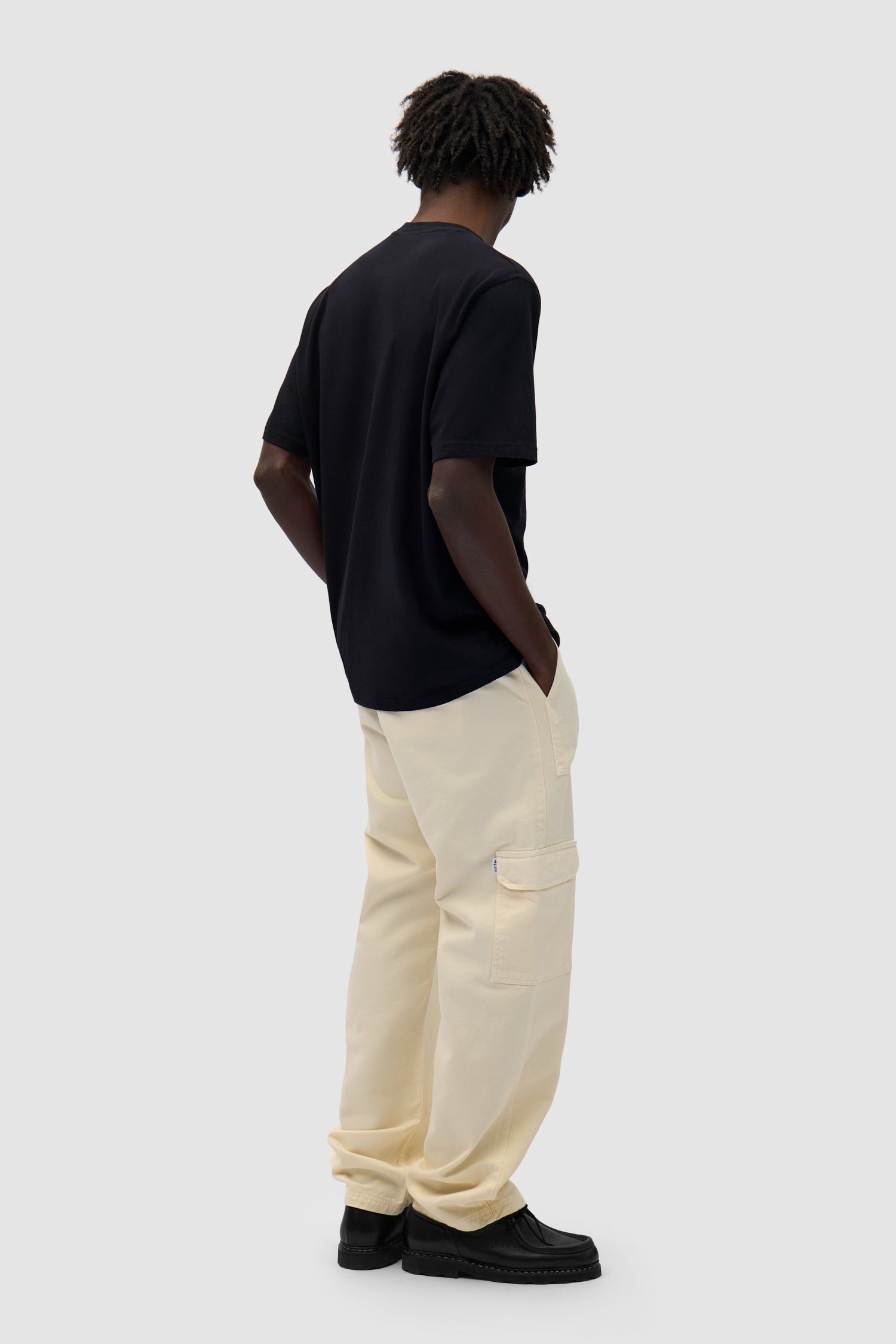 Cargo Pants in Cream worn by a model, full-body back view