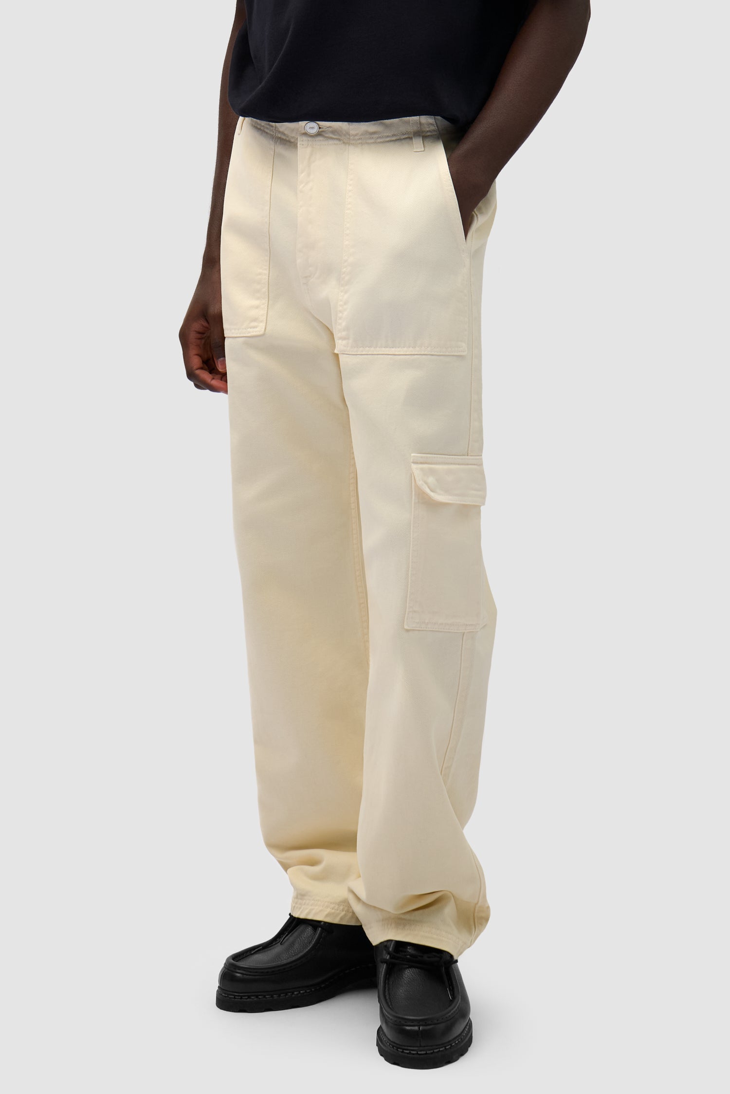 Cargo Pants in Cream worn by a model, half-body side view