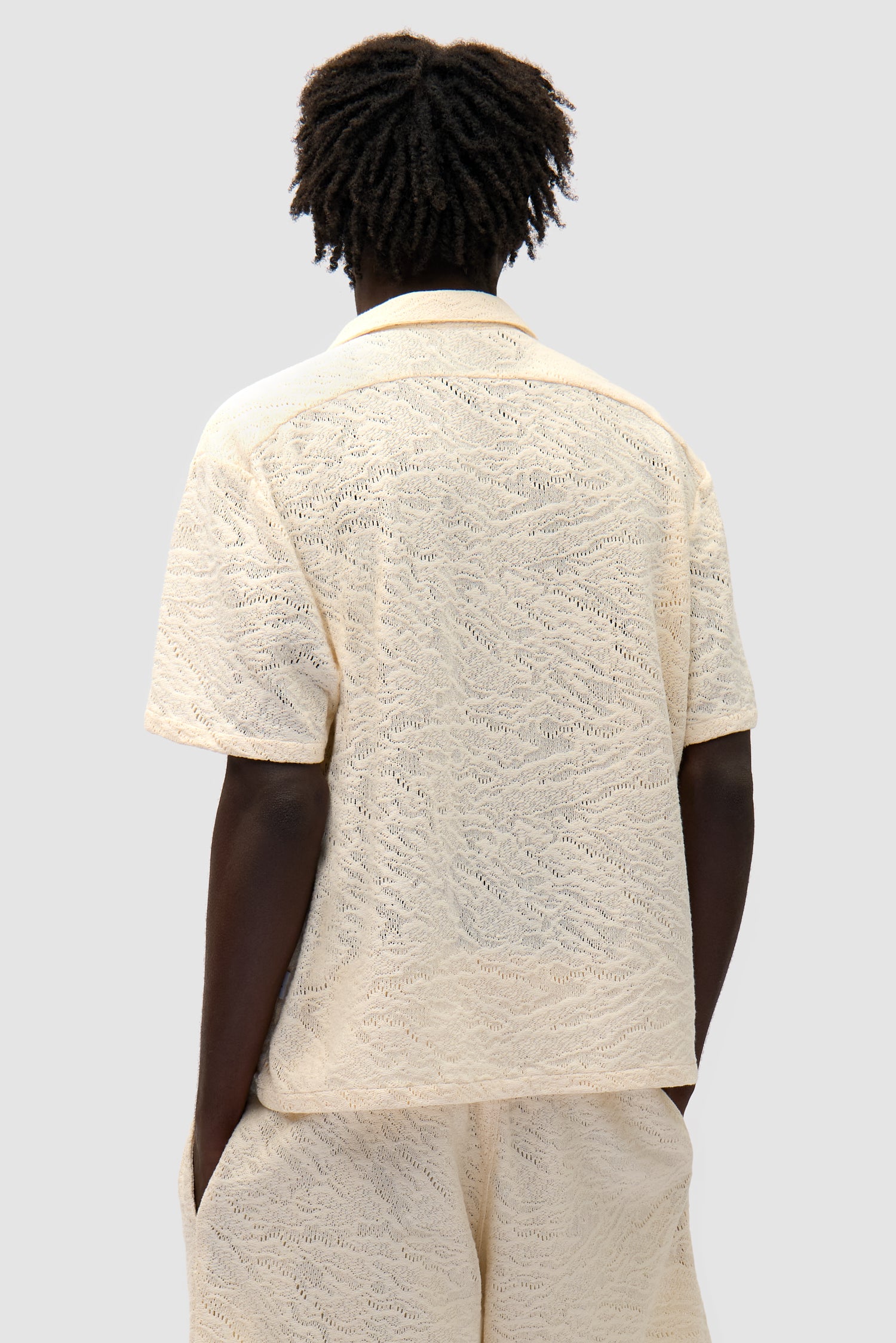 Crochet Shirt in Cream worn by a model, half-body back view