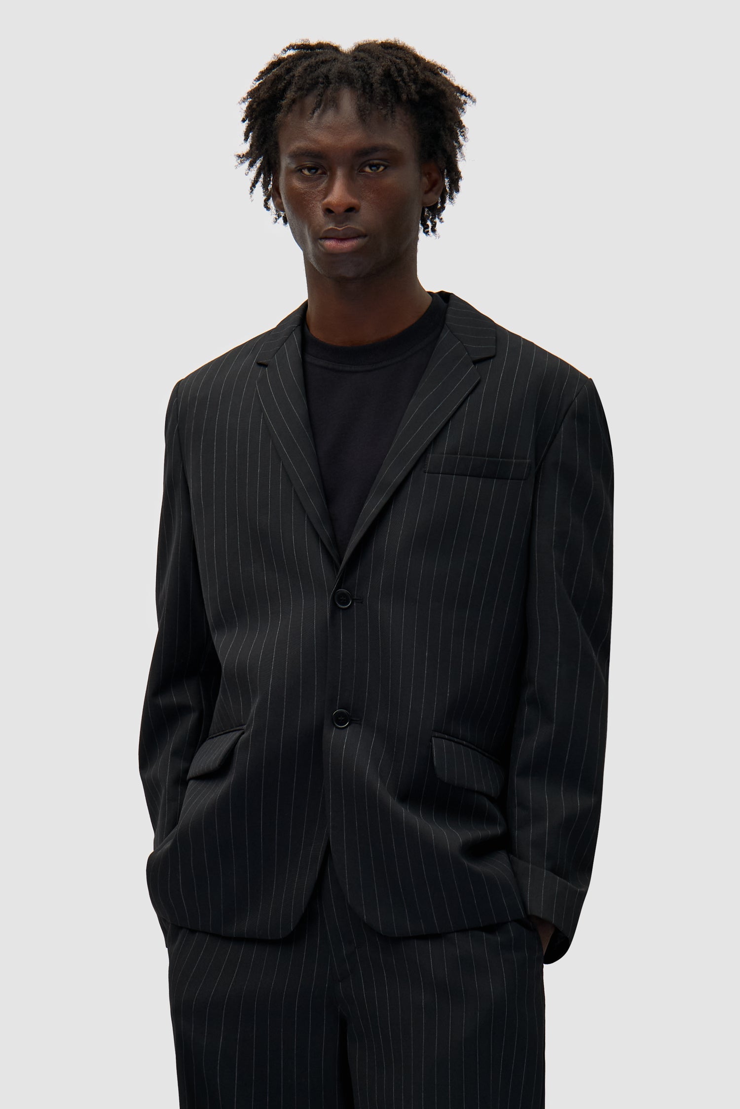 Suit Jacket in Black worn by a model, half-body front view