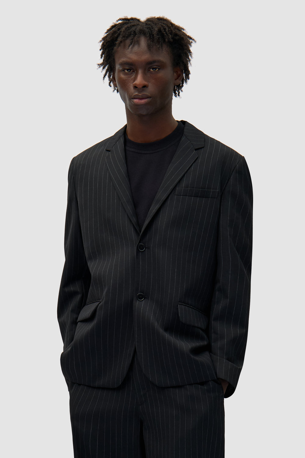 Suit Jacket in Black worn by a model, half-body front view