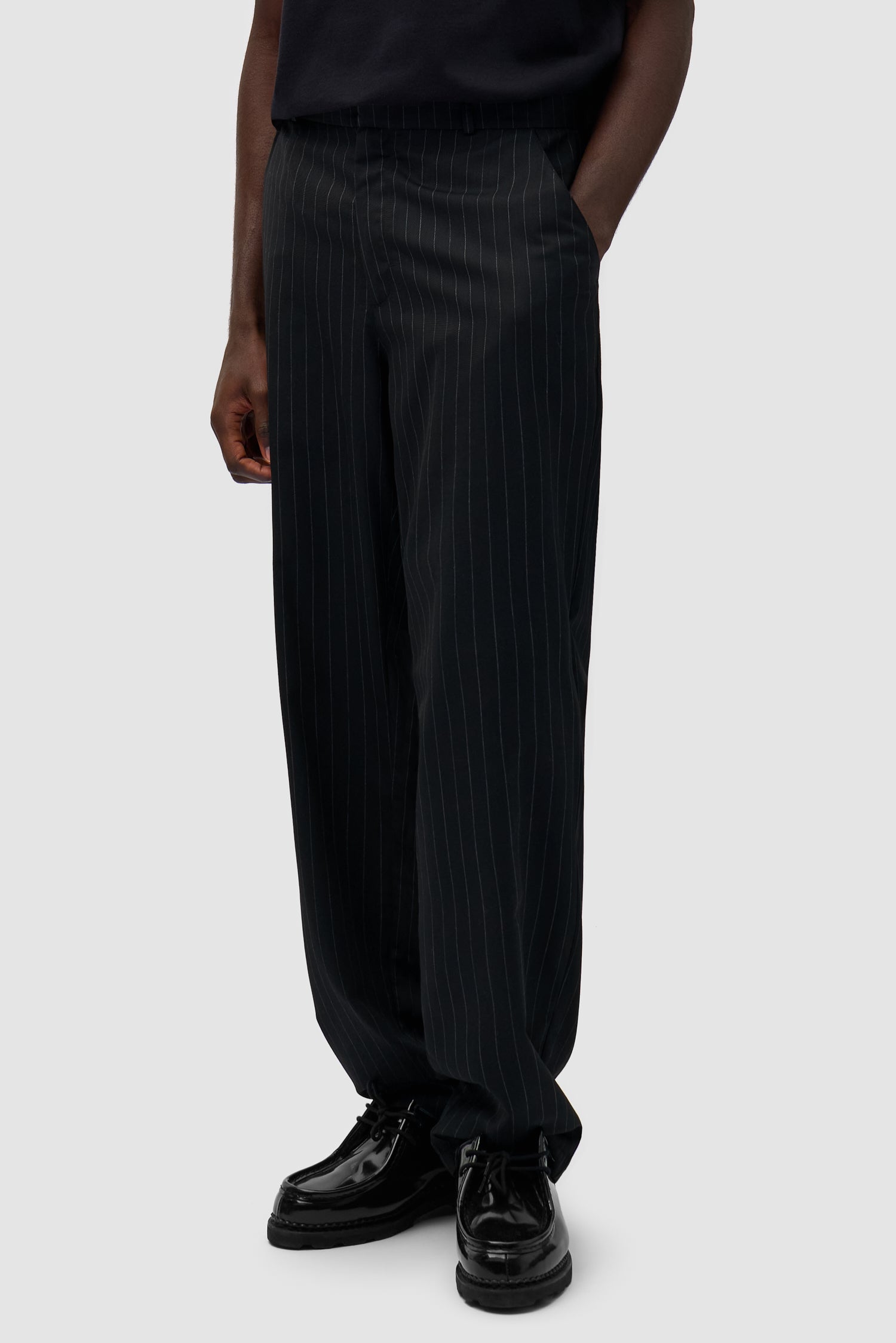 Suit Pants in Black worn by a model, half-body side view