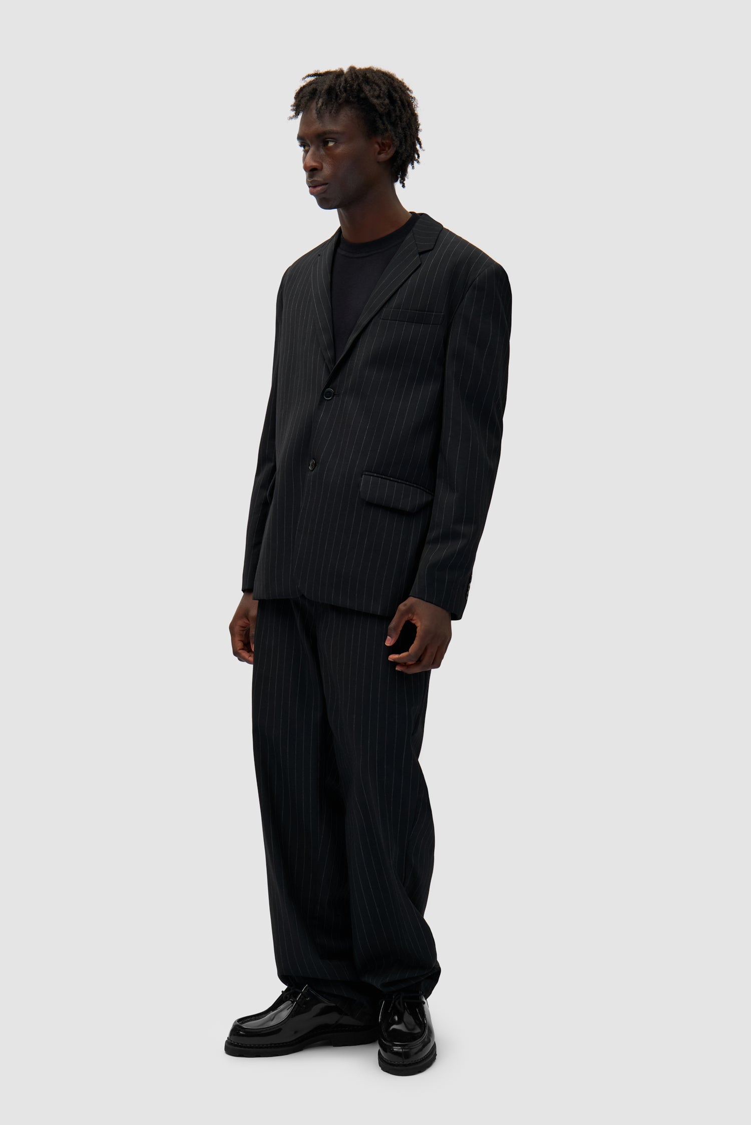 Suit Pants in Black worn by a model, full-body side view