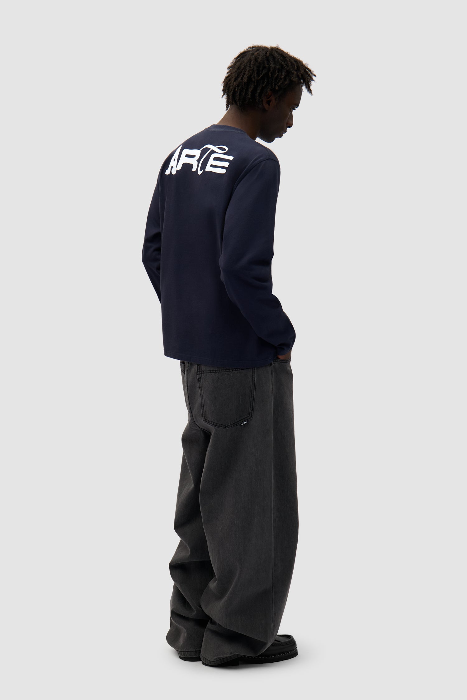 Good Energy Longsleeve in Navy worn by a model, full-body back view