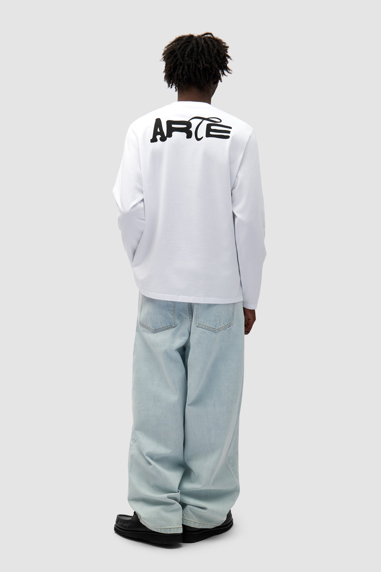 Good Energy Longsleeve in White worn by a model, full-body front view