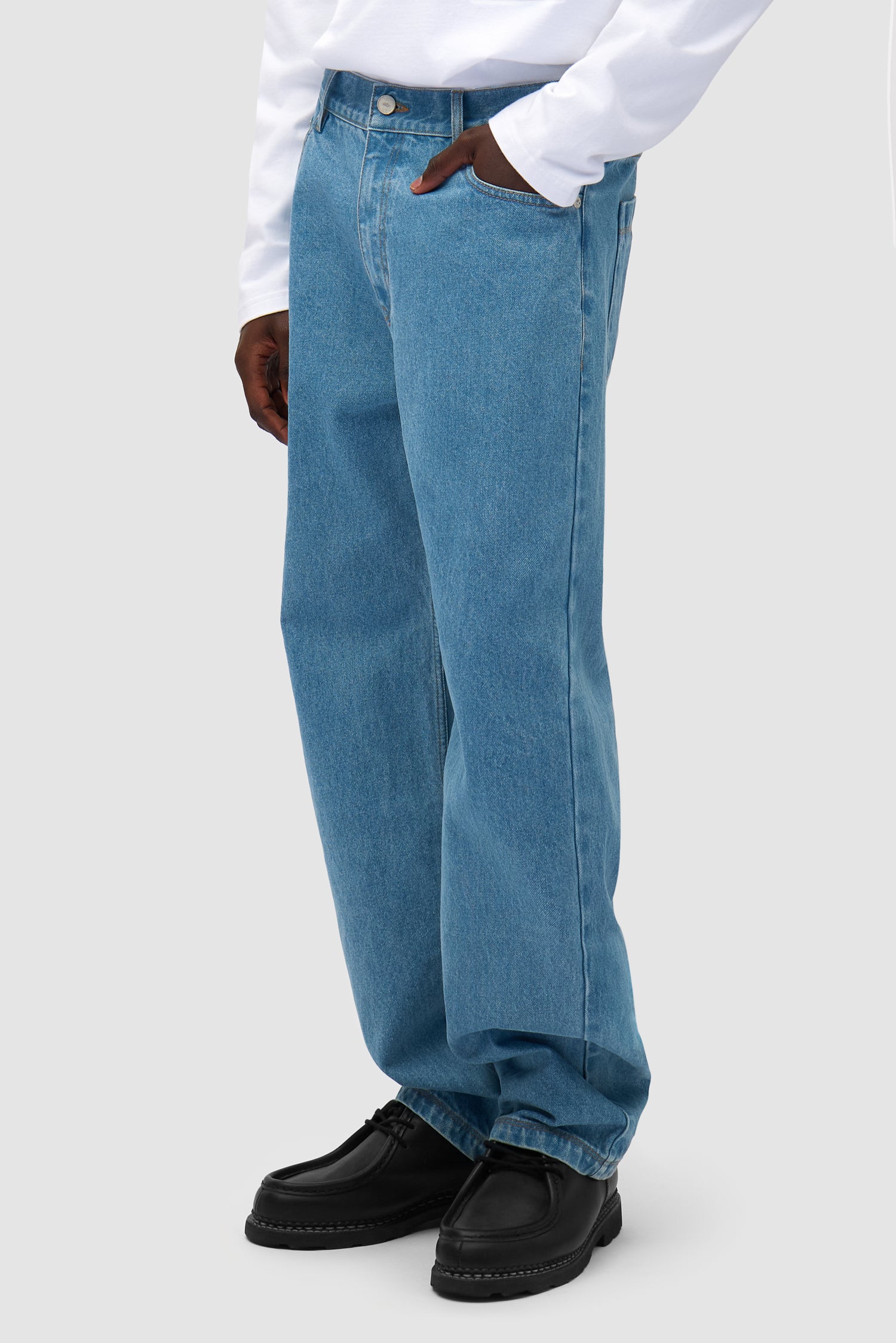 Bird Denim Pants in Bleach worn by a model, half-body side view
