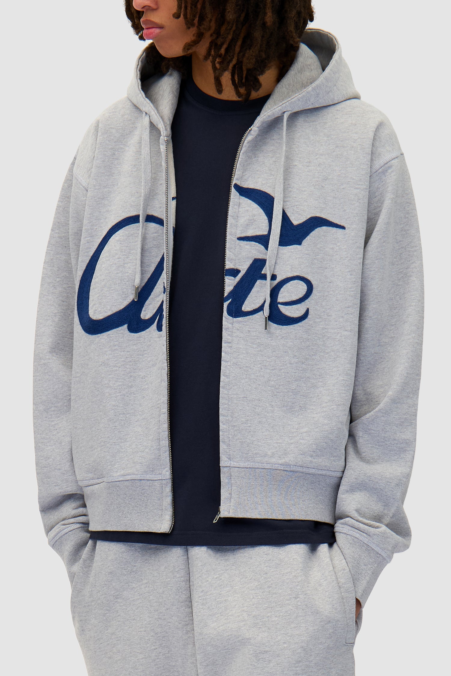 Zipper Hoodie in Grey worn by a model, half-body detailed view