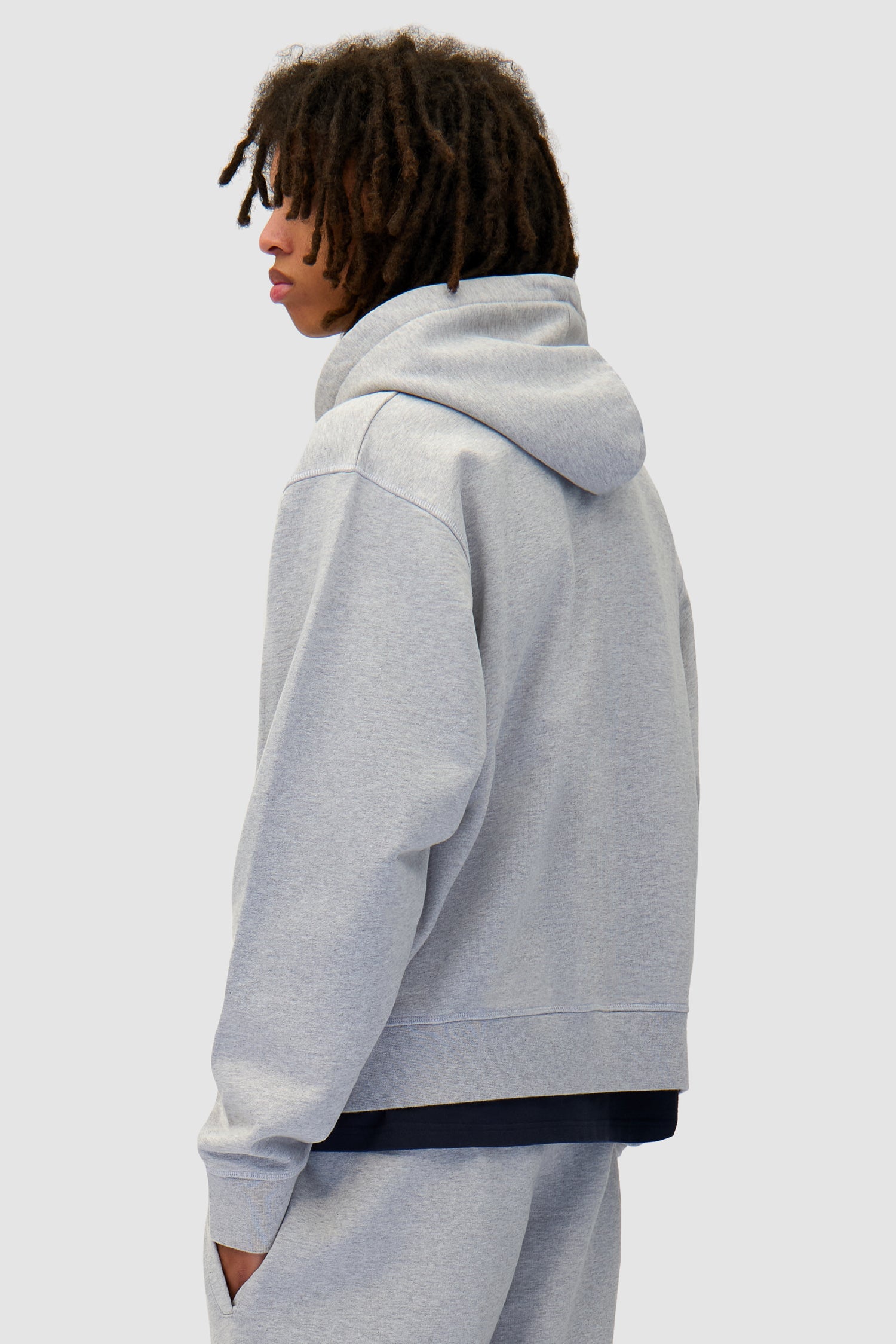 Zipper Hoodie in Grey worn by a model, half-body back view
