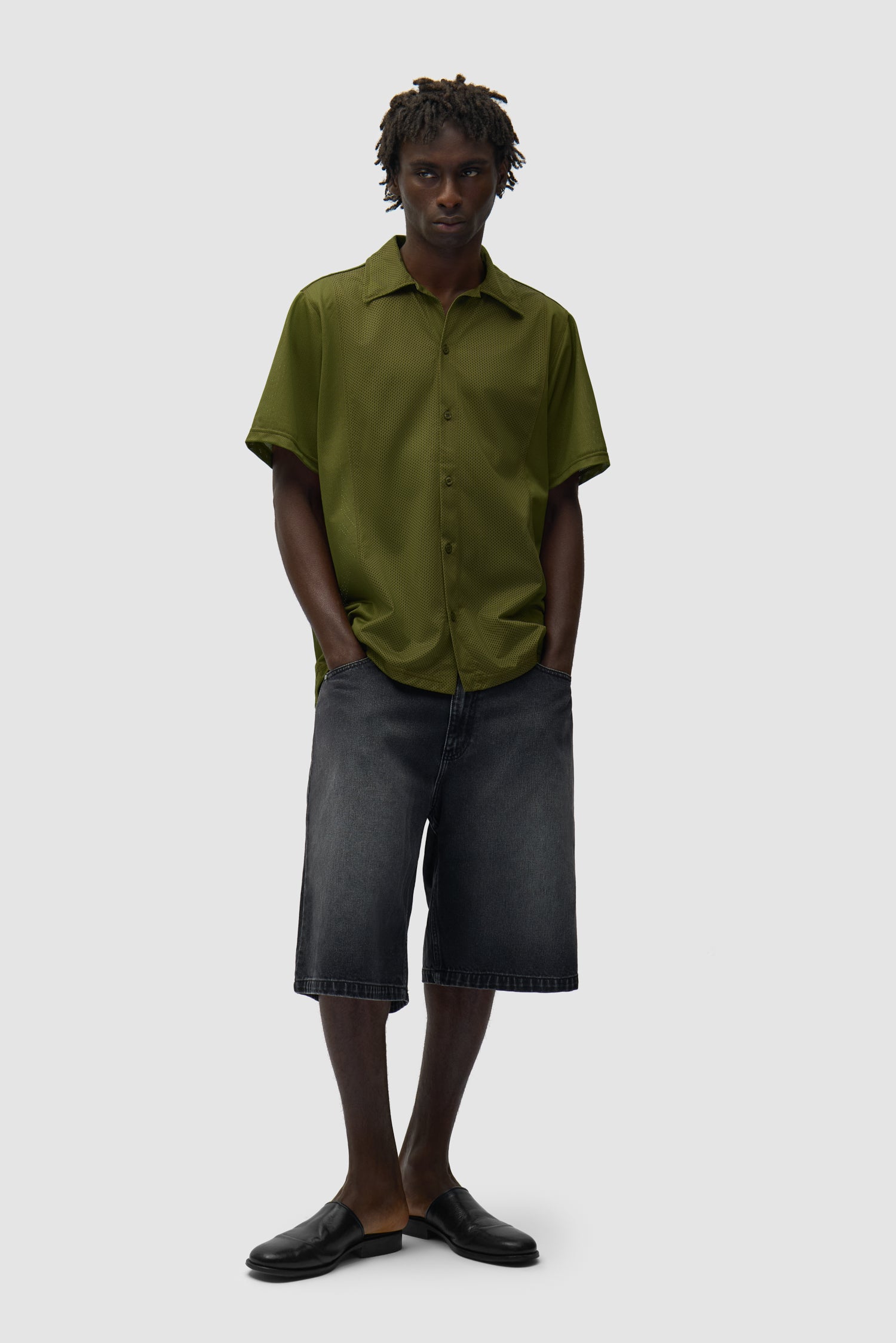 Chemise en maille verte portée par un mannequin, vue de profil en pied