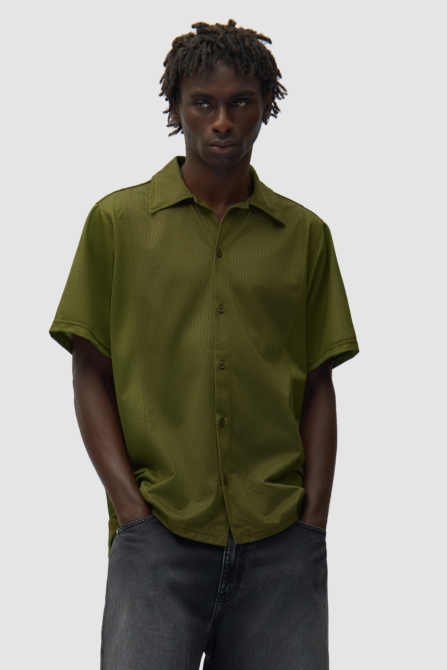 Chemise en maille verte portée par un mannequin, vue de face en demi-corps