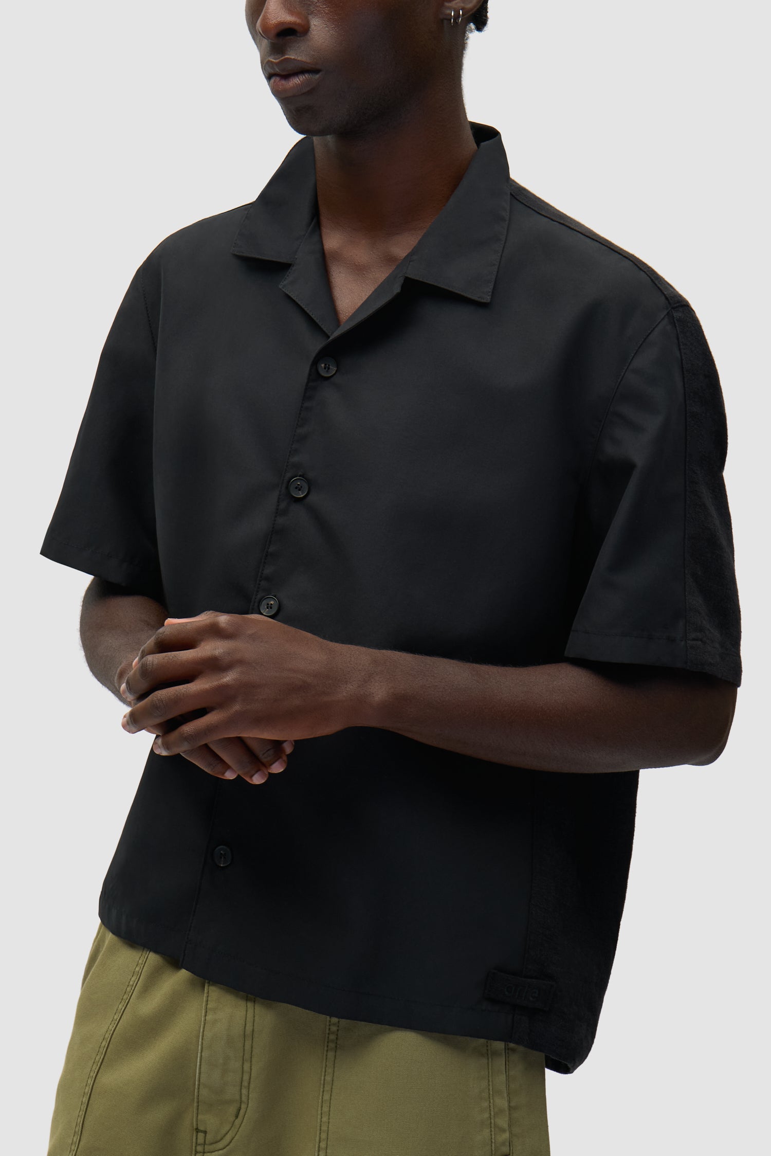 Chemise en lin et nylon noire portée par un mannequin, vue de profil à mi-corps