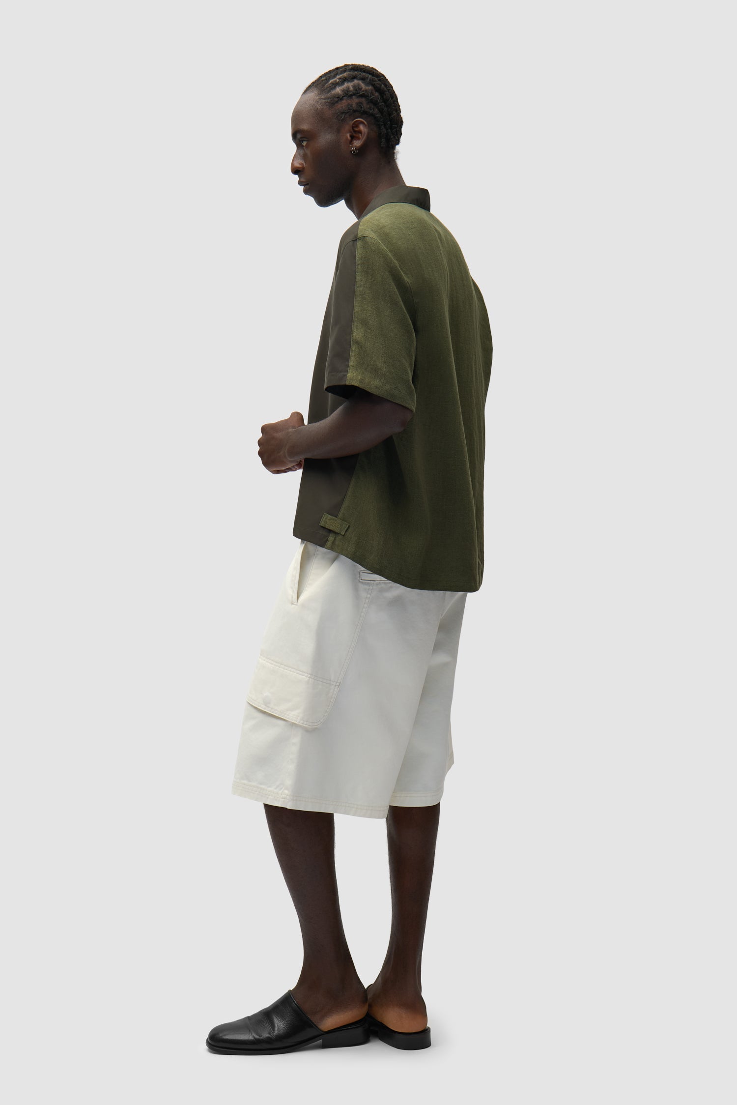 Chemise en lin et nylon verte portée par un mannequin, vue de profil en pied