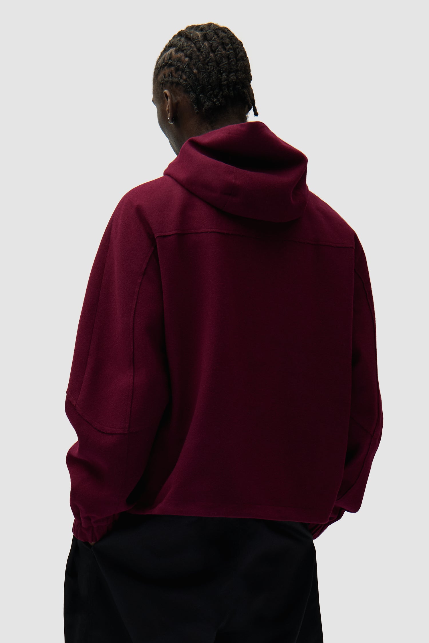 Veste technique en laine bordeaux portée par un mannequin, vue de dos à mi-corps