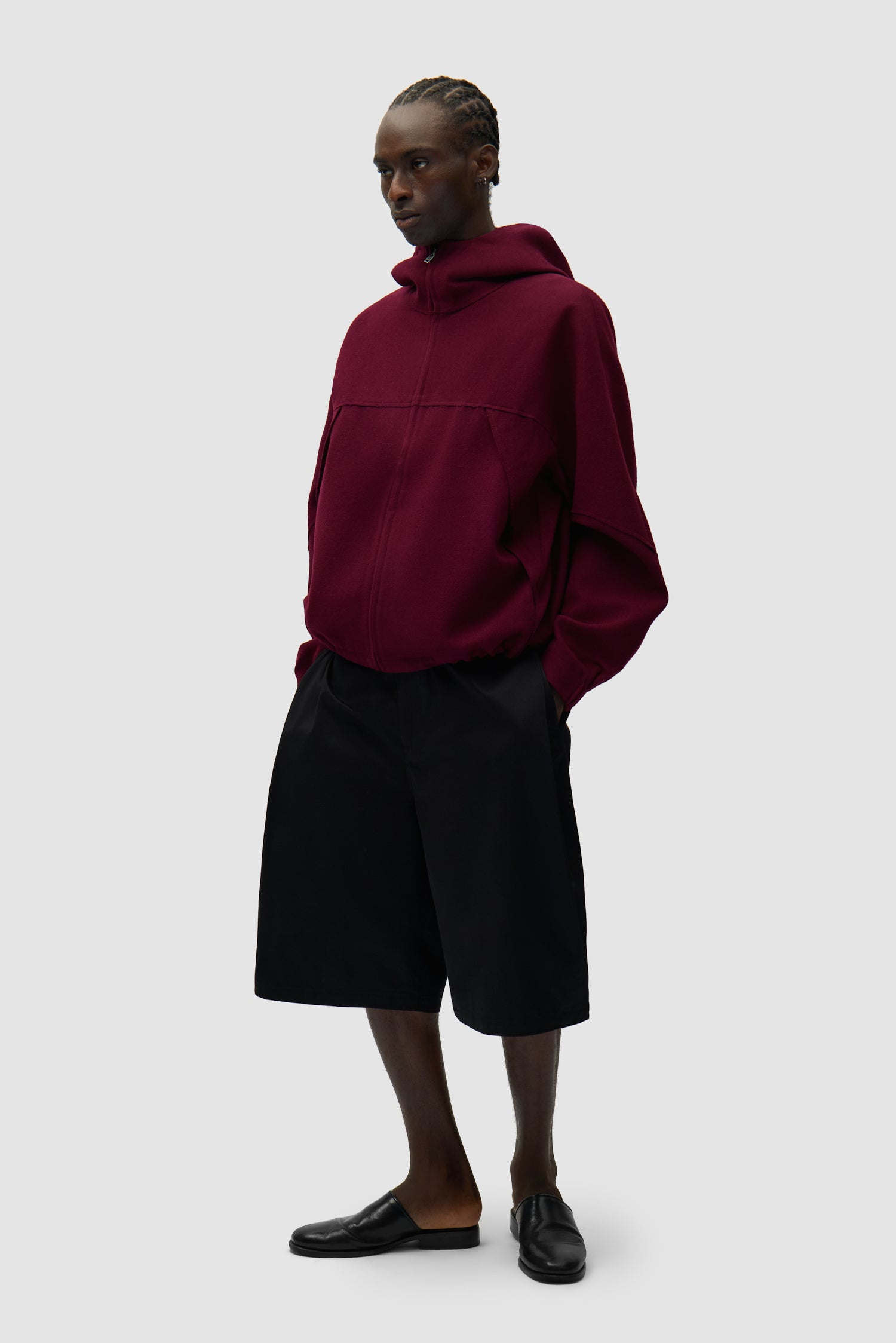 Veste technique en laine bordeaux portée par un mannequin, vue de face en pied