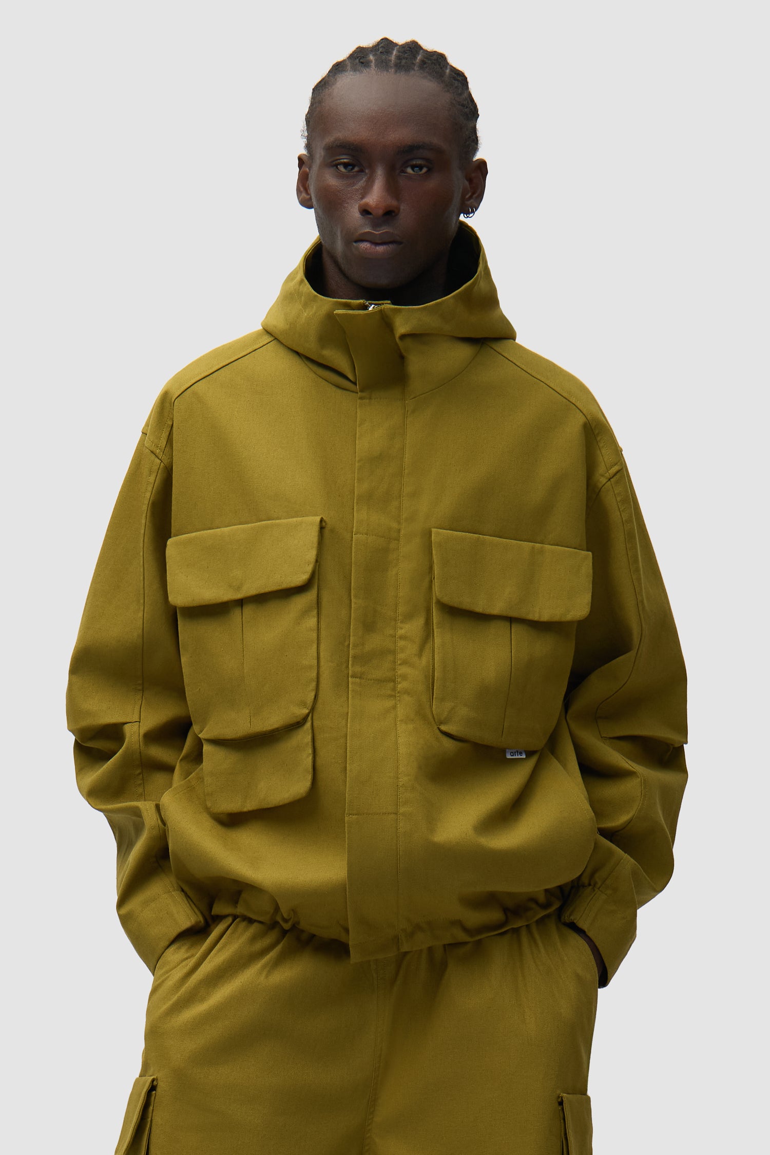 Veste technique en lin verte portée par un mannequin, vue de face en demi-corps