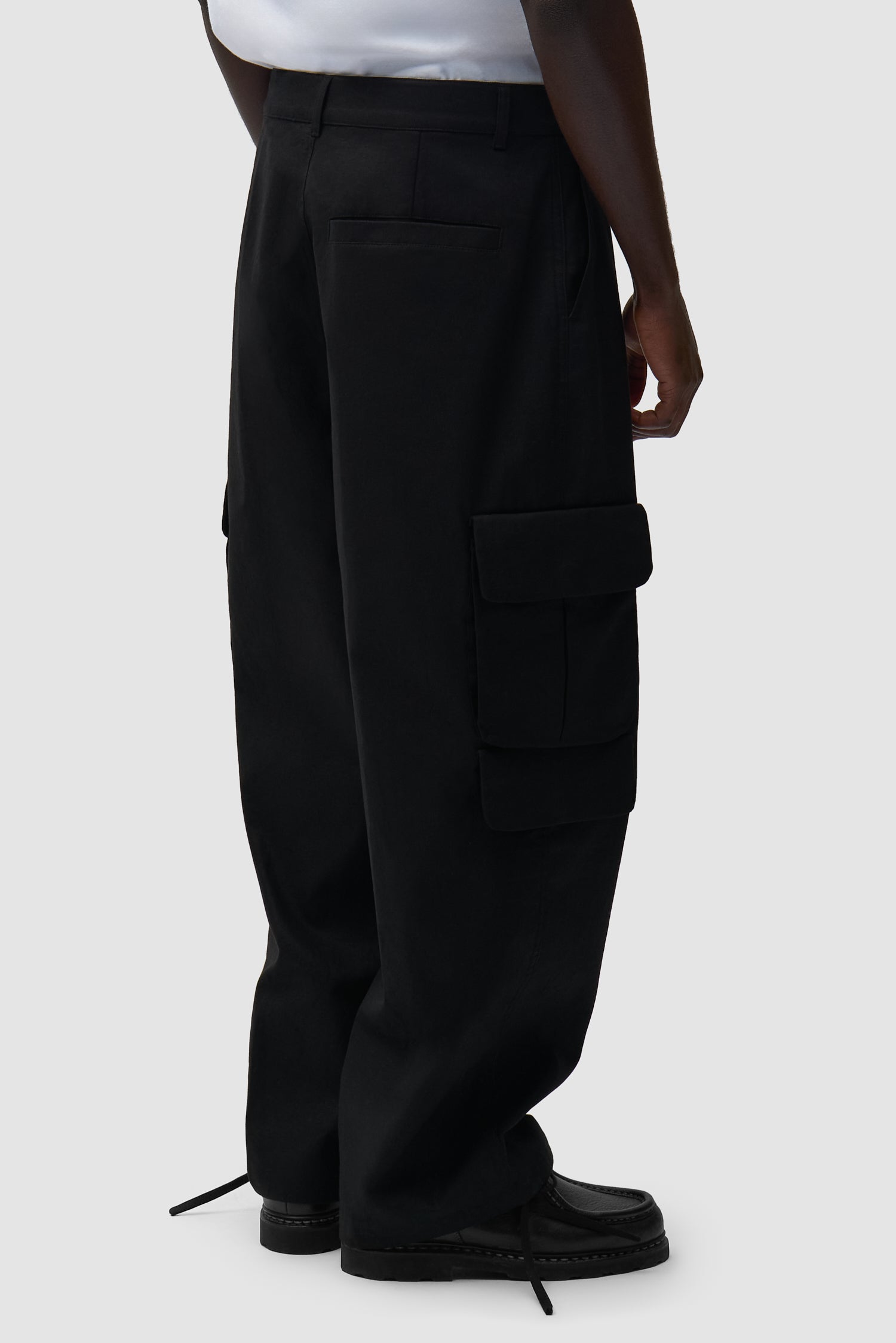 Pantalon cargo en lin noir porté par un mannequin, vue de dos à mi-corps