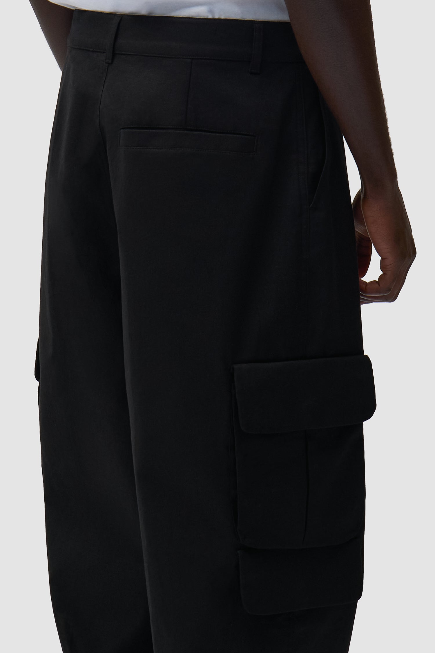 Vue détaillée du pantalon cargo en lin noir, avec logo